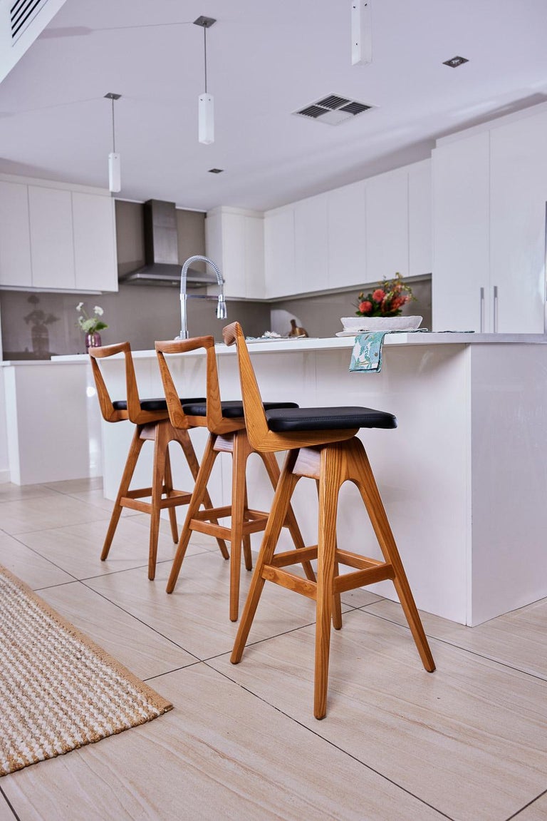 The TH Brown Danish bar stool was designed by Peter Brown and first manufactured from early 1960, and remains an iconic, timeless Australian design masterpiece to this day. The beautifully sculpted timber seat back, angled legs and hand stitched