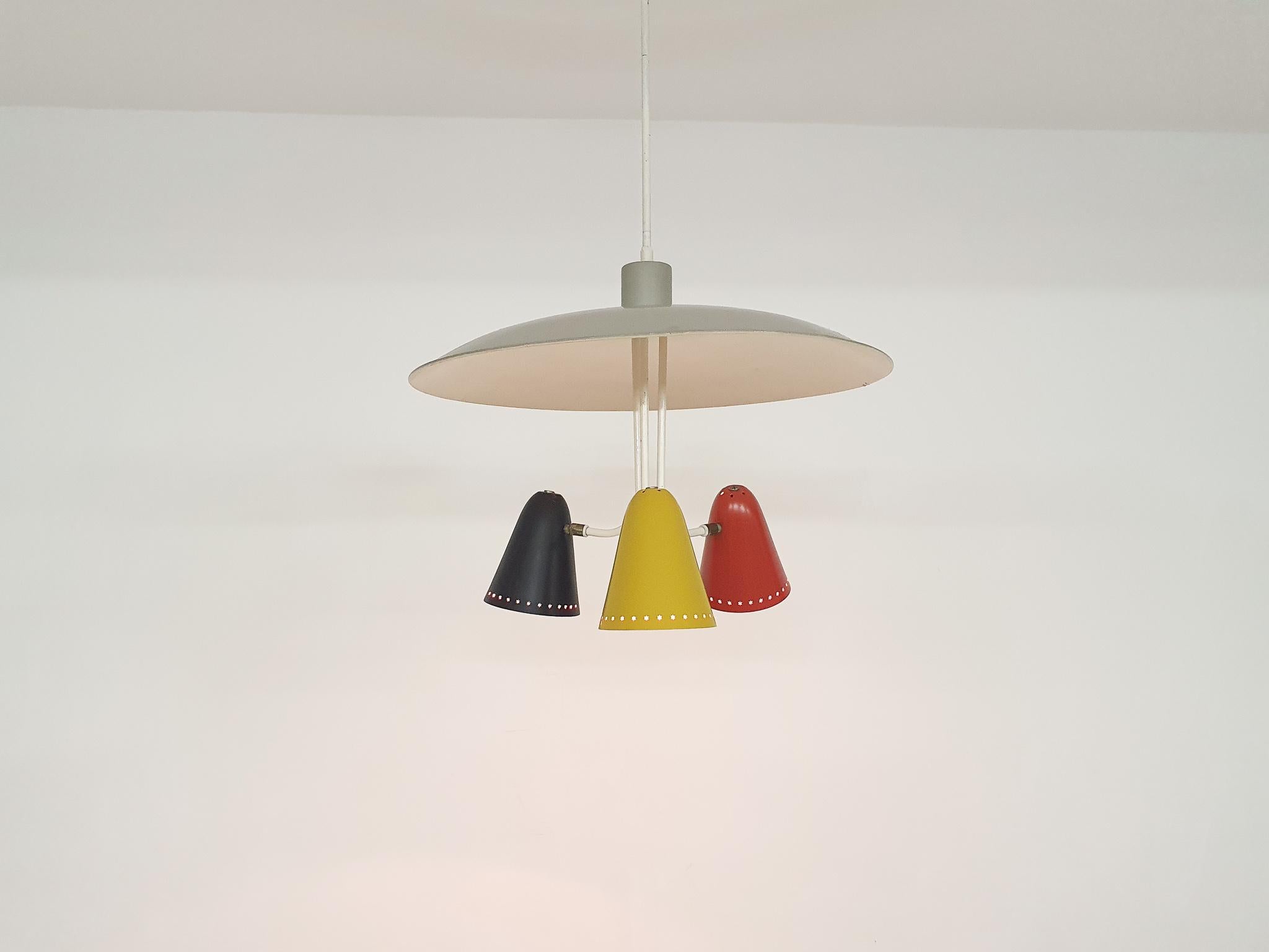 Metal pendant light. A grey scale with three metal lamp shades in yellow, red and black.
The lamp has been repainted in its original colors, and ahs new wiring.
The grey scale has some dents.