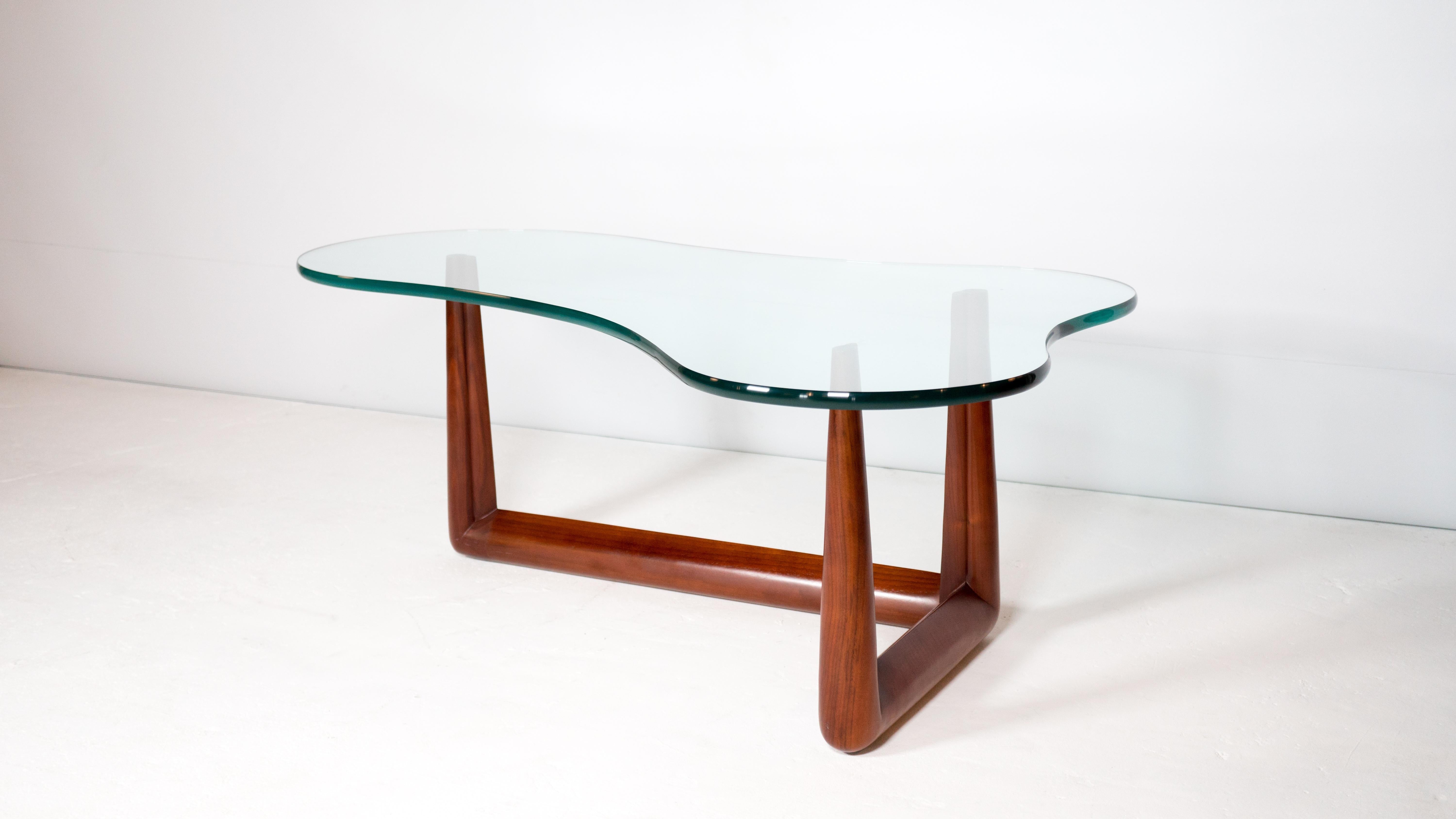 T.H. Robsjohn-Gibbings pour la table basse biomorphique Widdicomb. Base sculpturale en noyer massif présentant un magnifique grain de bois et un verre épais de 0,75