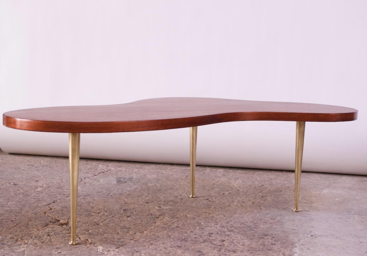 Iconic sculpted walnut biomorphic cocktail / coffee table with brass legs by Robsjohn-Gibbings for Widdicomb (1950, USA). Walnut has been refinished and brass legs have been newly polished. Only minor wear remains (namely, light wear to the