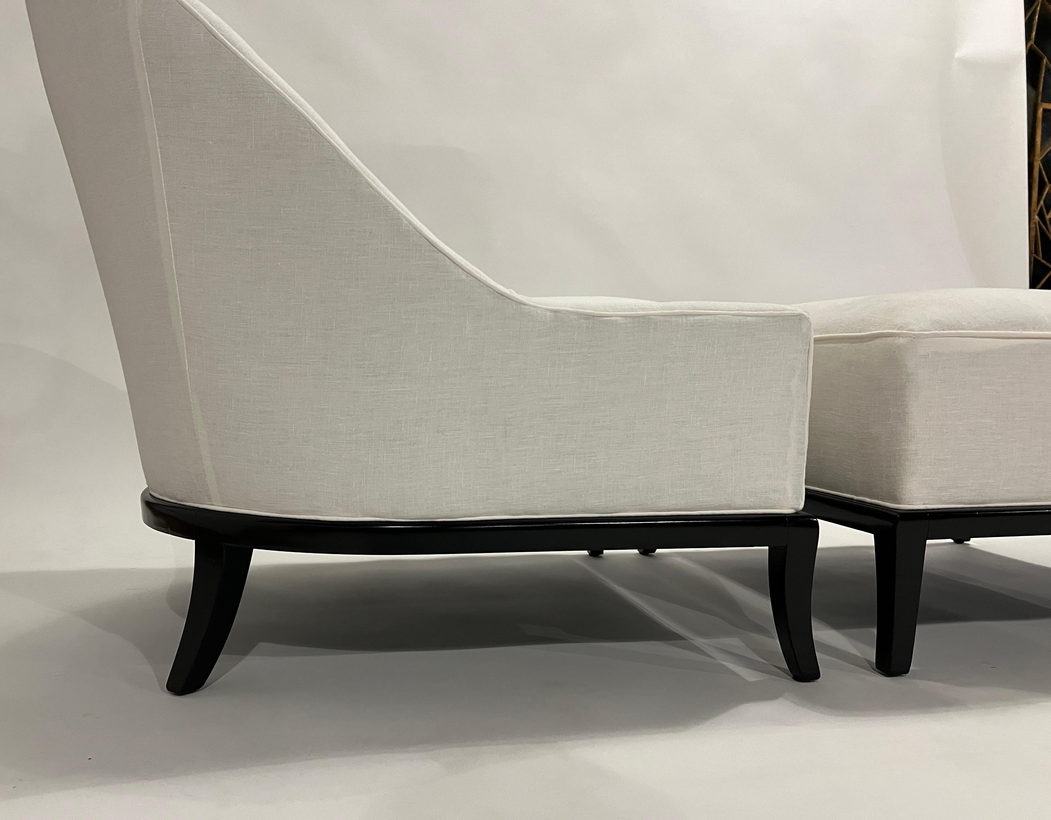 Chic and rare upholstered spoon lounge chair and ottoman set designed by T.H. Robsjohn Gibbings for Widdicomb, 1950's. 

The walnut frame has been lacquered in ebony and the chair has been upholstered in a white linen fabric. 

Chair measures 26