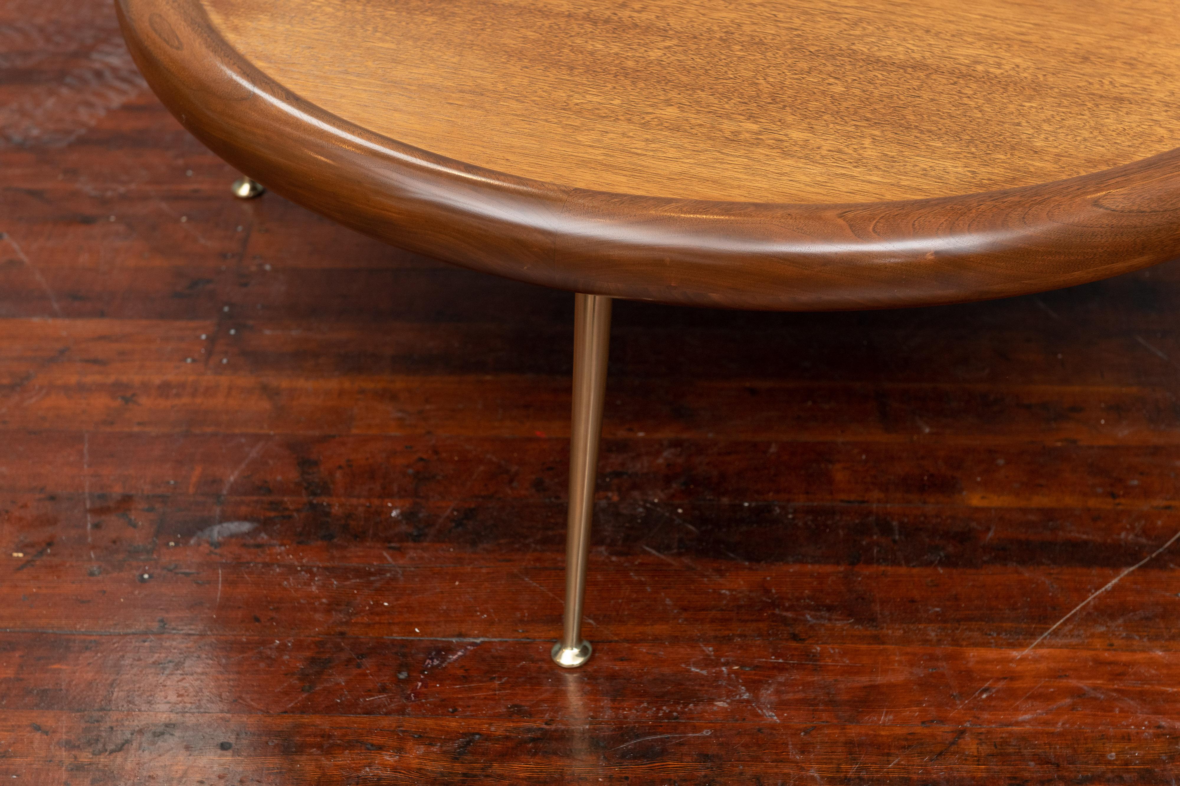 T.H. Robsjohn-Gibbings design round walnut coffee table for Widdicomb Furniture Co. Perfectly refinished in a medium walnut semigloss finish on polished brass legs and a sculptural bull nose trim, labelled.