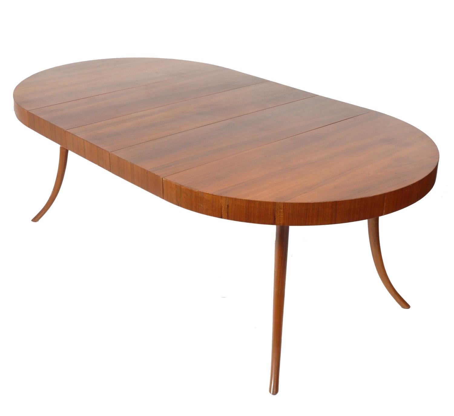 Elegant midcentury dining table, designed by T. H. Robsjohn-Gibbings for Widdicomb of Canada, circa 1950s. Clean lined design with elegant splayed legs. It expands from a compact 44