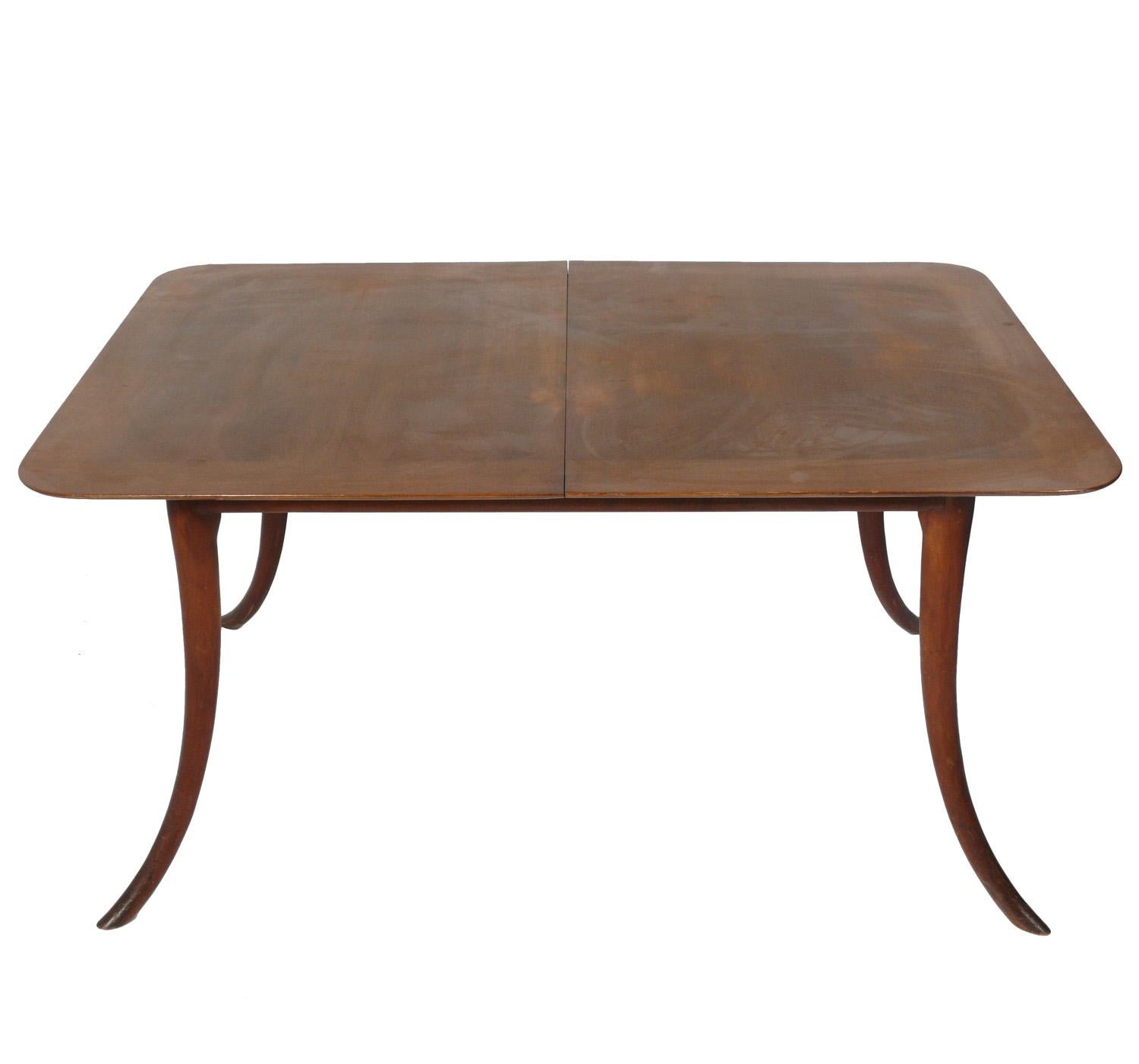Elegant mid century dining table, designed by T. H. Robsjohn-Gibbings for Widdicomb, American, circa 1950s. Clean lined design with elegant splayed legs. It expands from 58-78