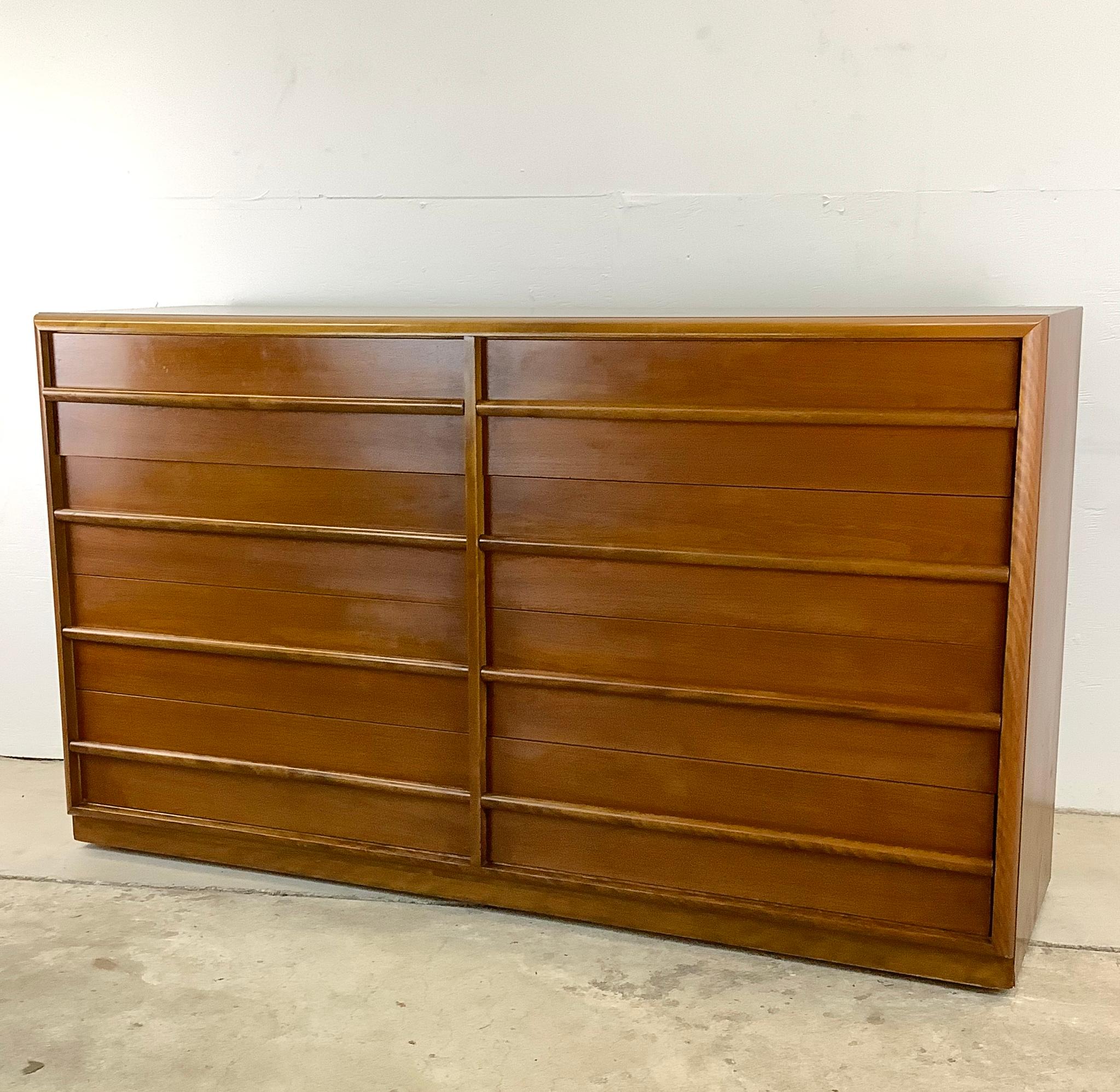 This exquisite eight-drawer double dresser, designed by the esteemed T.H. Robsjohn-Gibbings for Widdicomb, embodies the essence of mid-century elegance. The dresser's spacious interior offers ample storage space for an organized and clutter-free