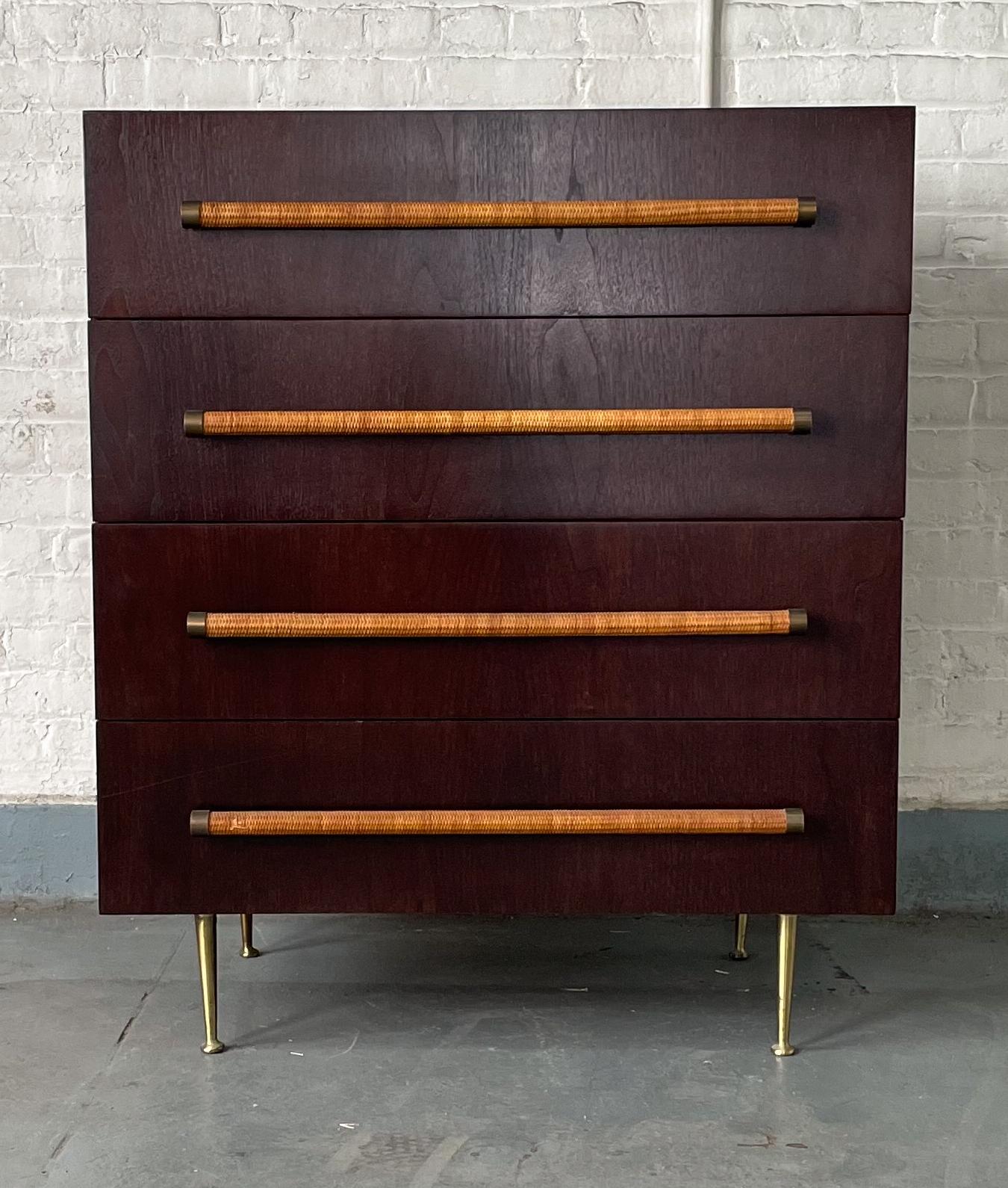 Stylish and useful four-drawer dresser by T.H. Robsjohn-Gibbings, produced by Widdicomb Furniture circa 1950's. Dark walnut frame with tapered brass legs and raffia caned pulls with brass accents. Solid secondary wood. Top two drawers have their