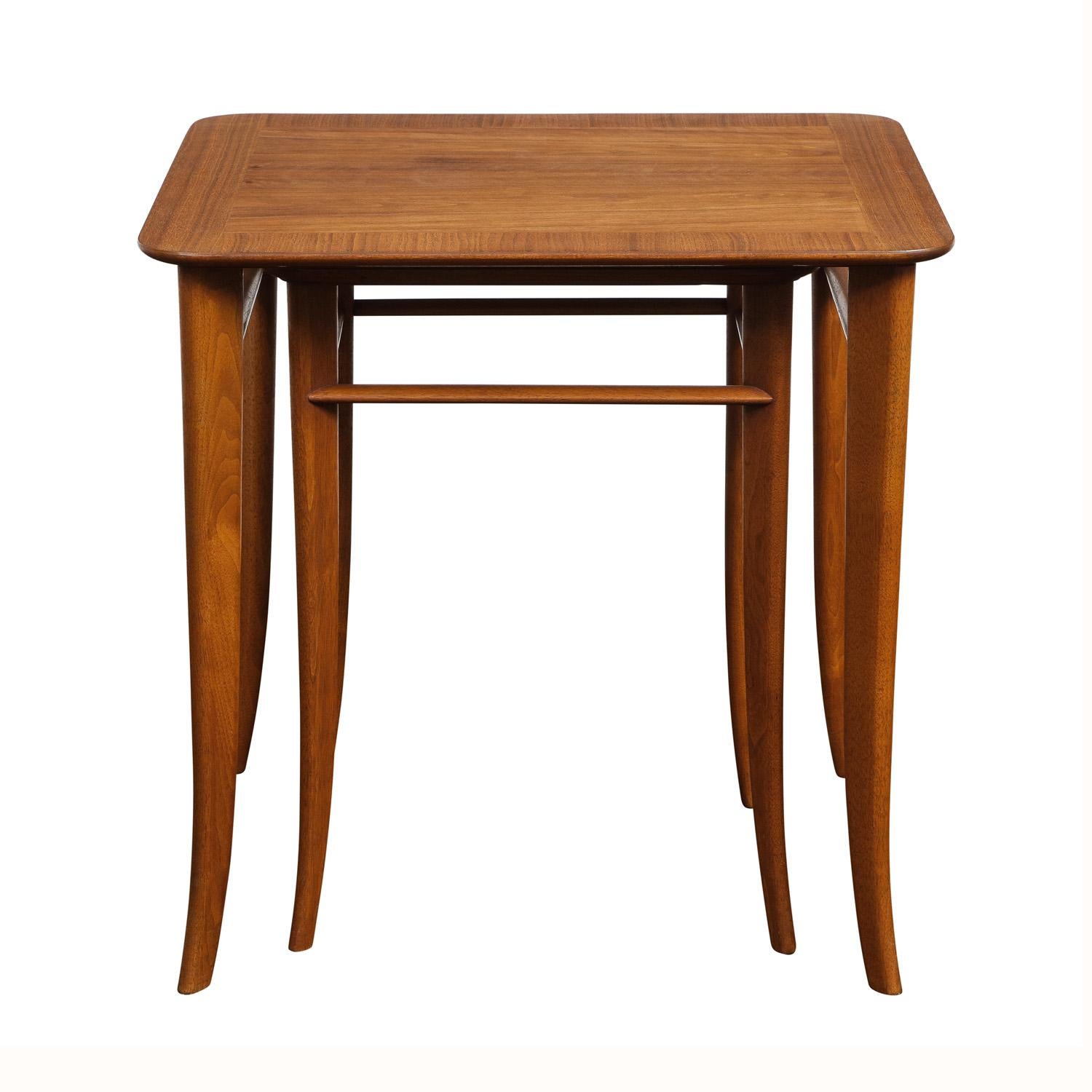 Classic pair of nesting tables model 3323 in walnut with flared leg design by T.H. Robsjohn-Gibbings for Widdicomb, American 1950's. These tables are very elegant and beautifully made.

Reference:  This set of nesting tables is shown in the