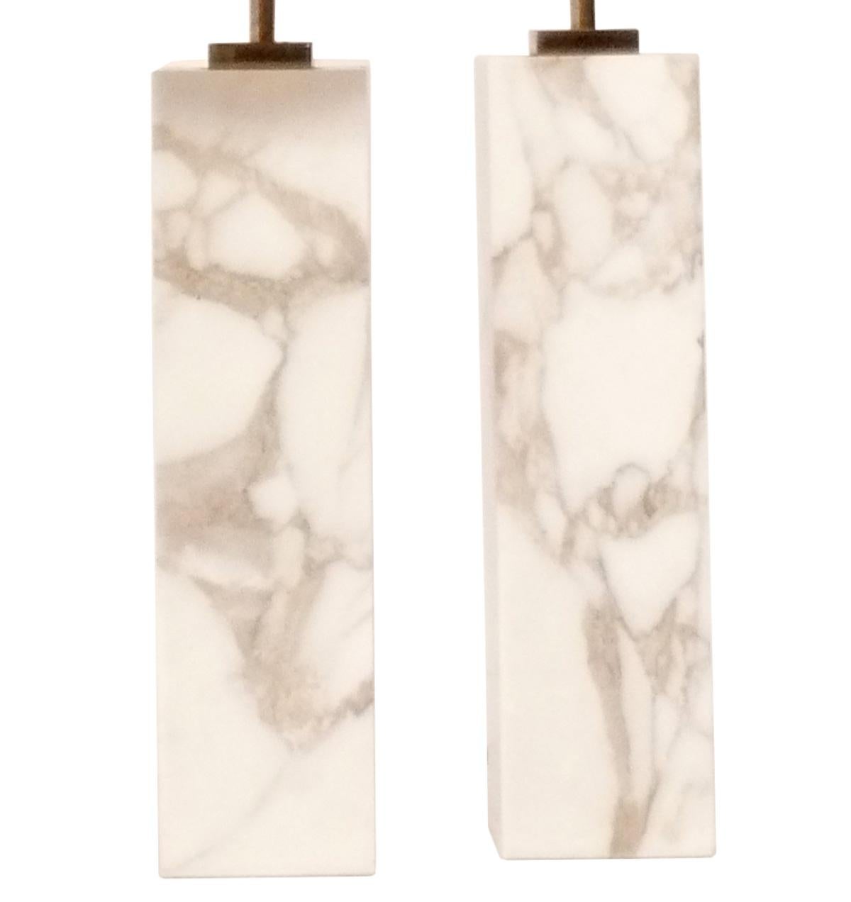 Pair of Clean Lined Marble Lamps, designed by T.H. Robsjohn Gibbings for Hansen, American, circa 1950s. These are vintage originals and retain their warm original patina to the brass fittings. The marble is a beautiful ivory color field with greige