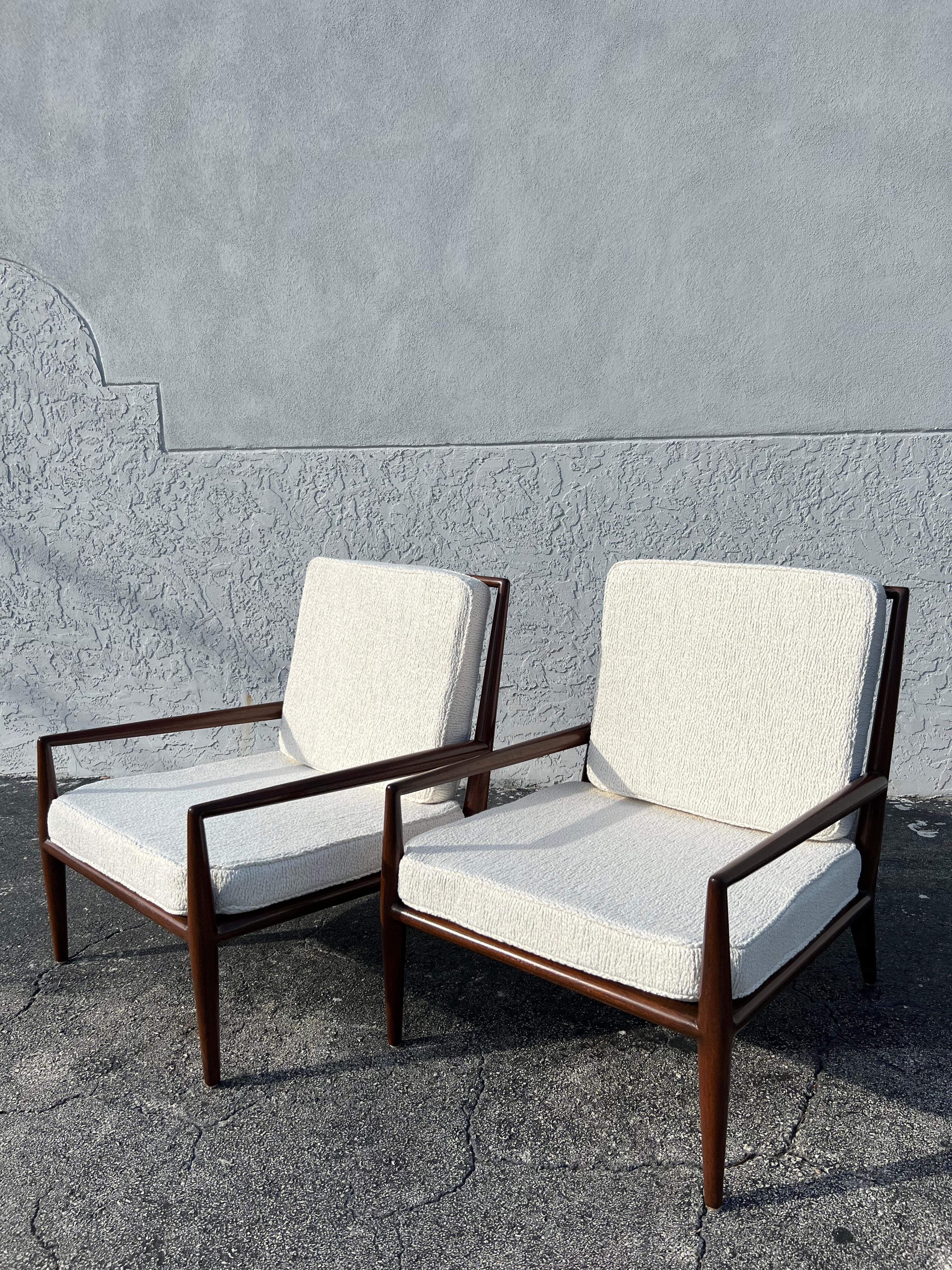 Pair of T.H Robsjohn-Gibbings attributed lounge chairs. Walnut frames have been refinished and upholstery updated to boucle. The platforms were intentionally left original so as to not disturb the original webbing supports (please refer to photos).