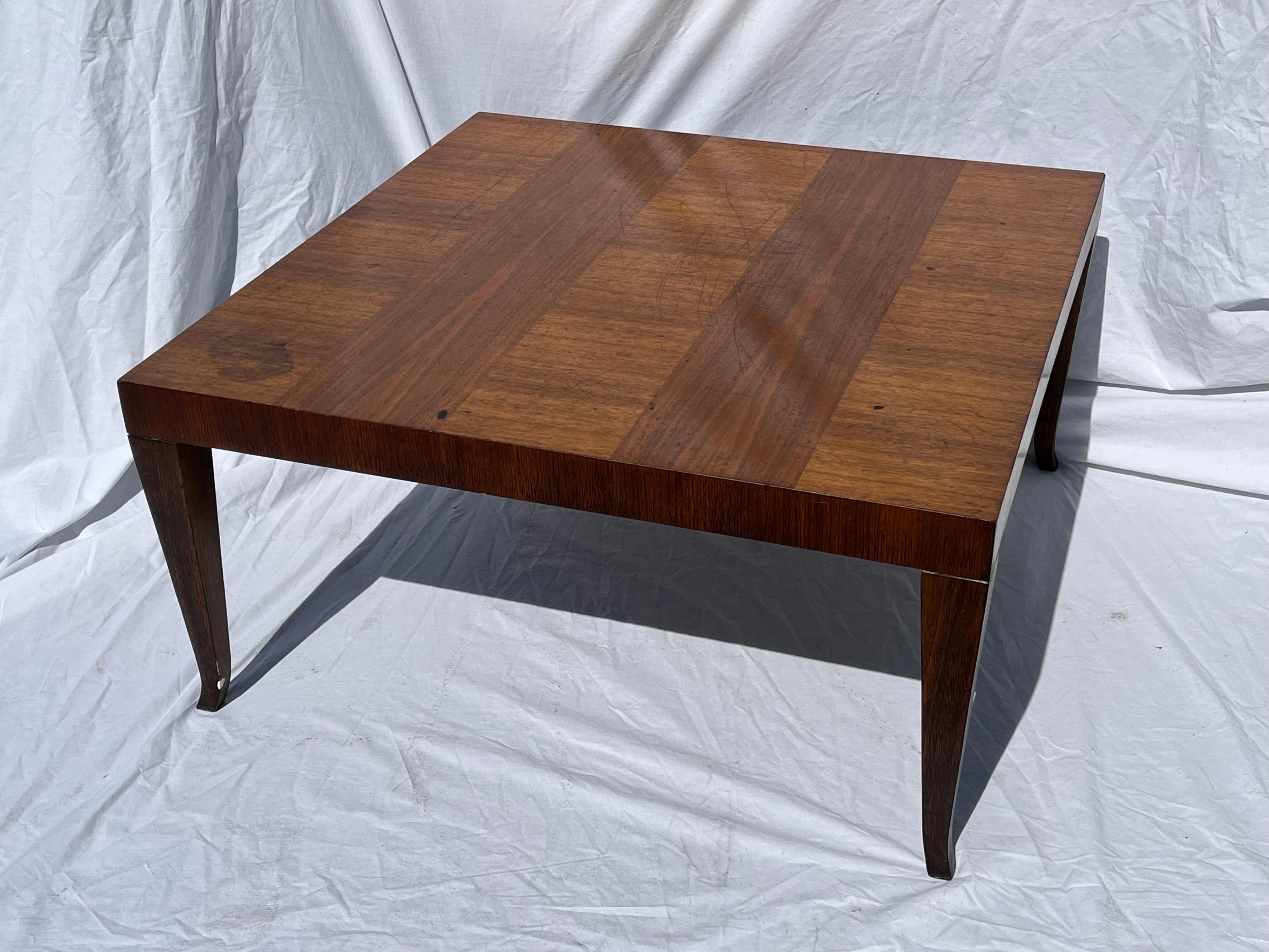 A Mid-20th century, circa 1950s coffee table designed by T. H. Robsjohn-Gibbings for Widdicomb. The beautifully grained wood is expressed in a strip design on the top of the table. The slightly splayed, saber style legs elegantly support the large