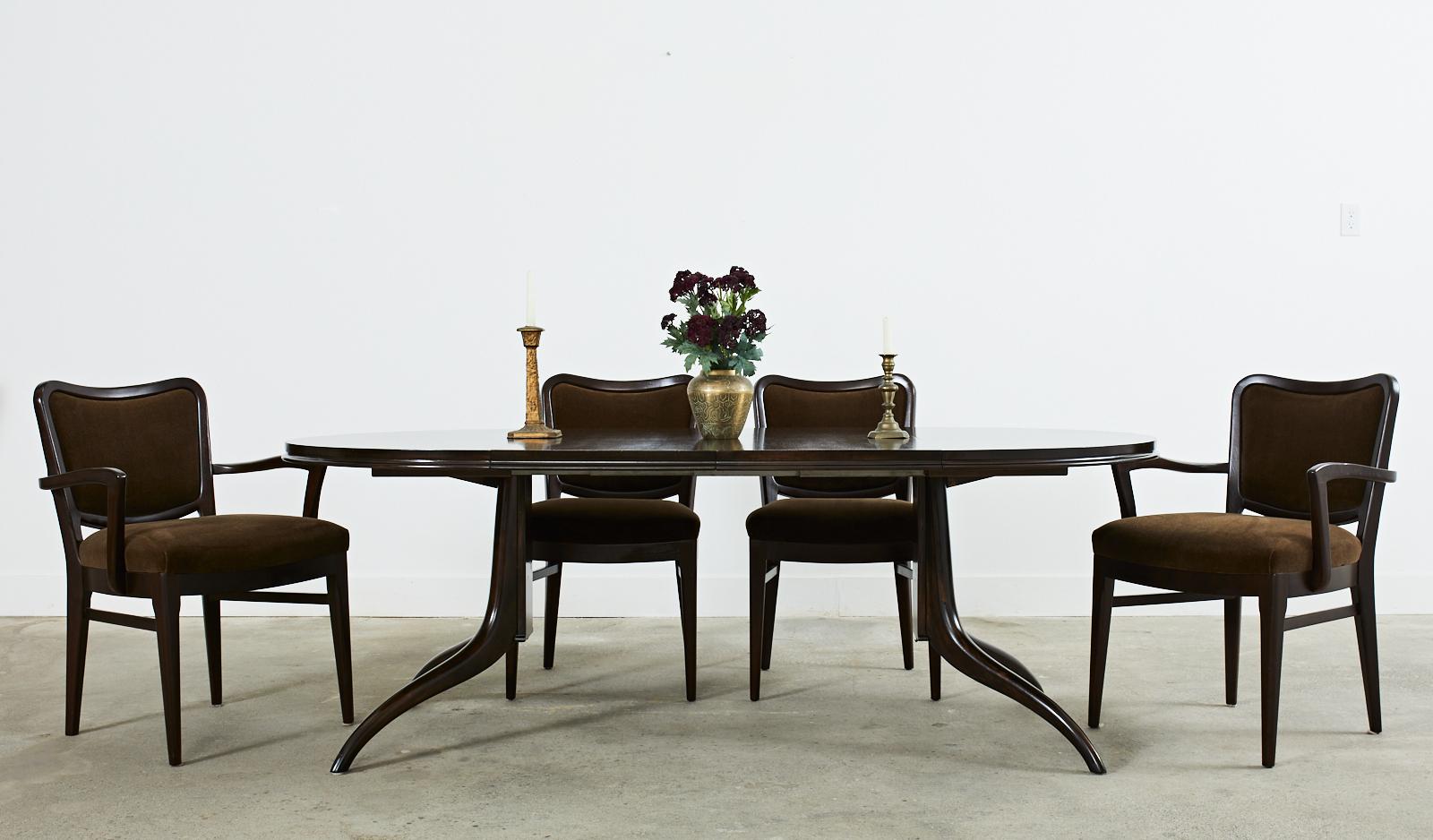 Elegant Mid-Century Modern dining table designed by T.H. Robsjohn-Gibbings for Widdicomb Furniture Co. The table features two 18 inch leaves that extend the top from 44.5 inches round to an oval or race track form measuring 80.5 inches wide. Crafted