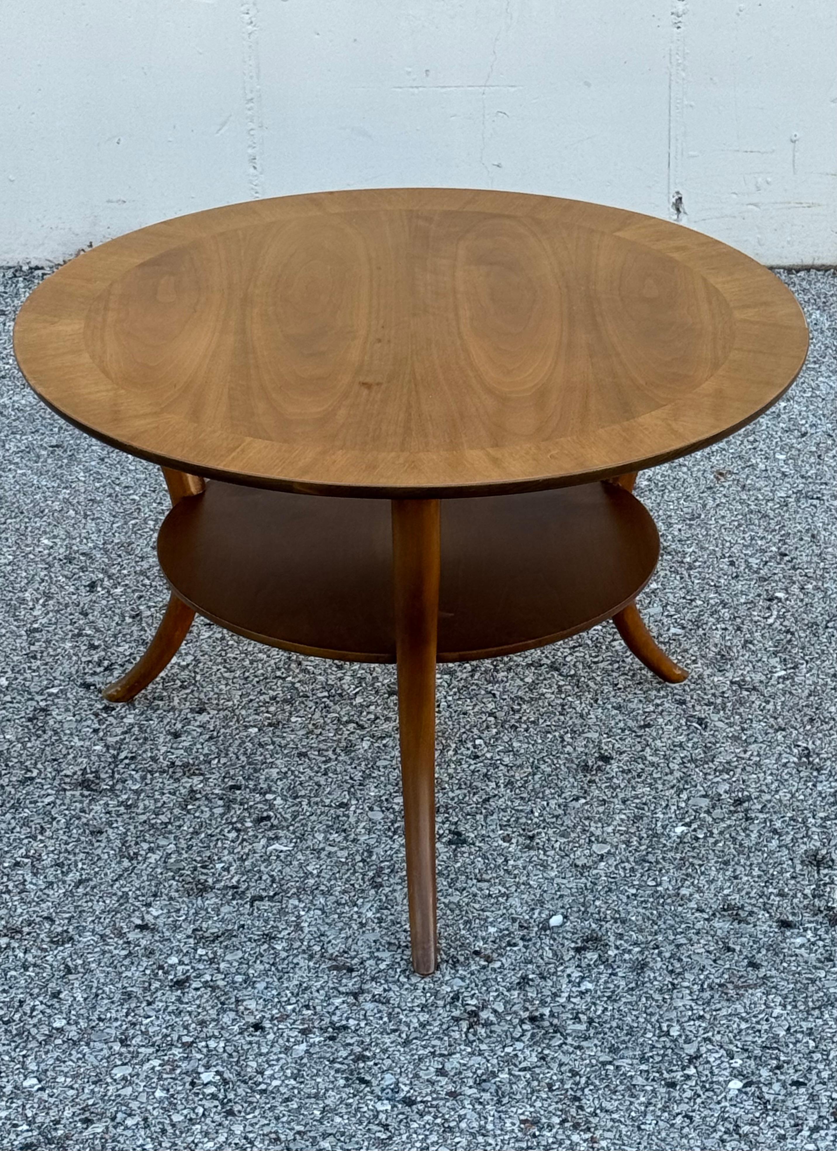 Classic 1950s T.H. Robsjohn-Gibbings for Widdicomb round end table with lower shelf on three Klismos sabre-legs. Top has beautiful book matched walnut veneer with a boarder, includes original glass top. Widdicomb label, dated 1957.  