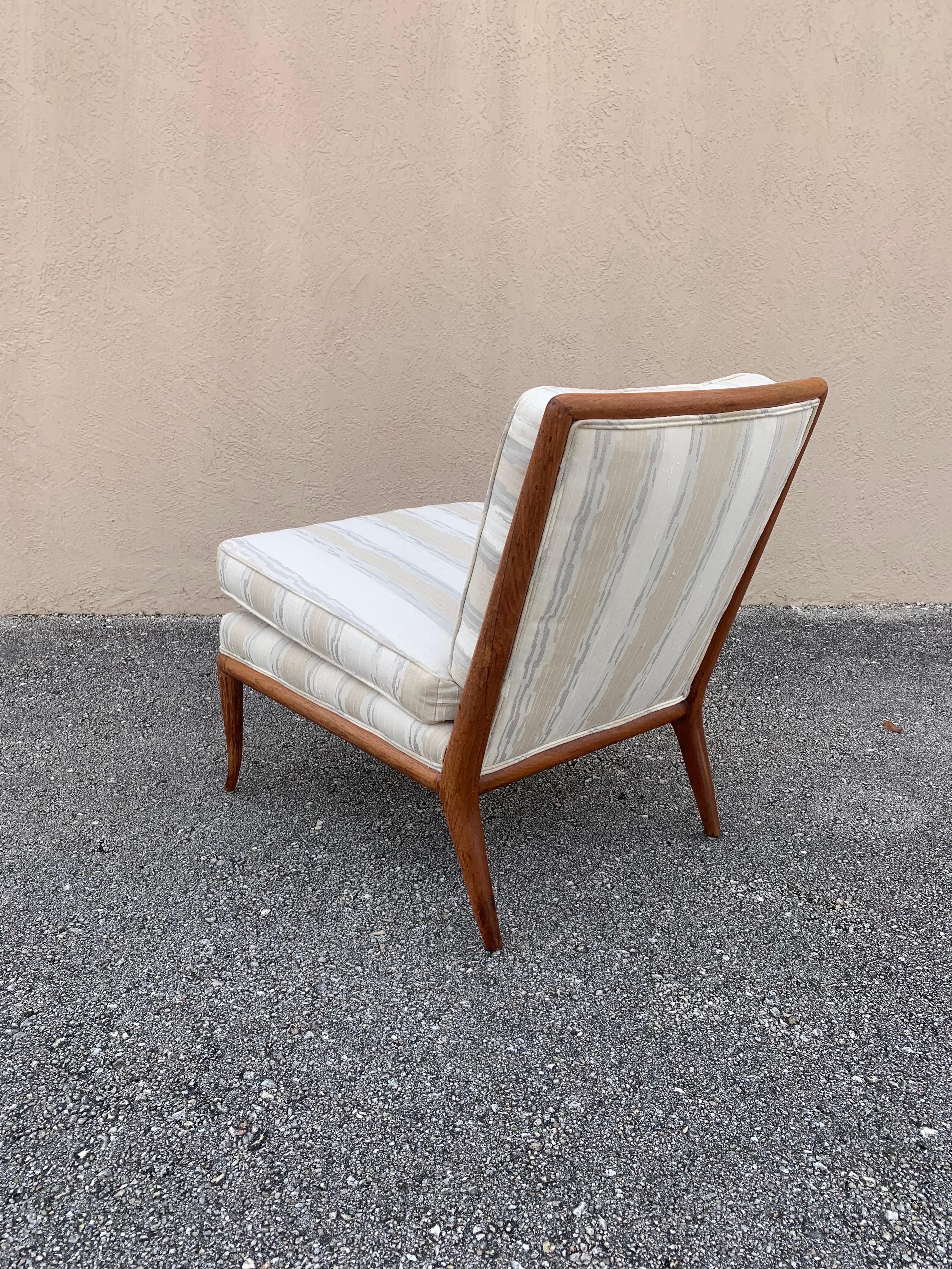Timeless elegant design by T.H. Robsjohn-Gibbings in original finish. Believed to be original upholstery but could have been redone in its lifetime. Some stains to the upholstery could be updated or cleaned. Frame has original finish. Shows some