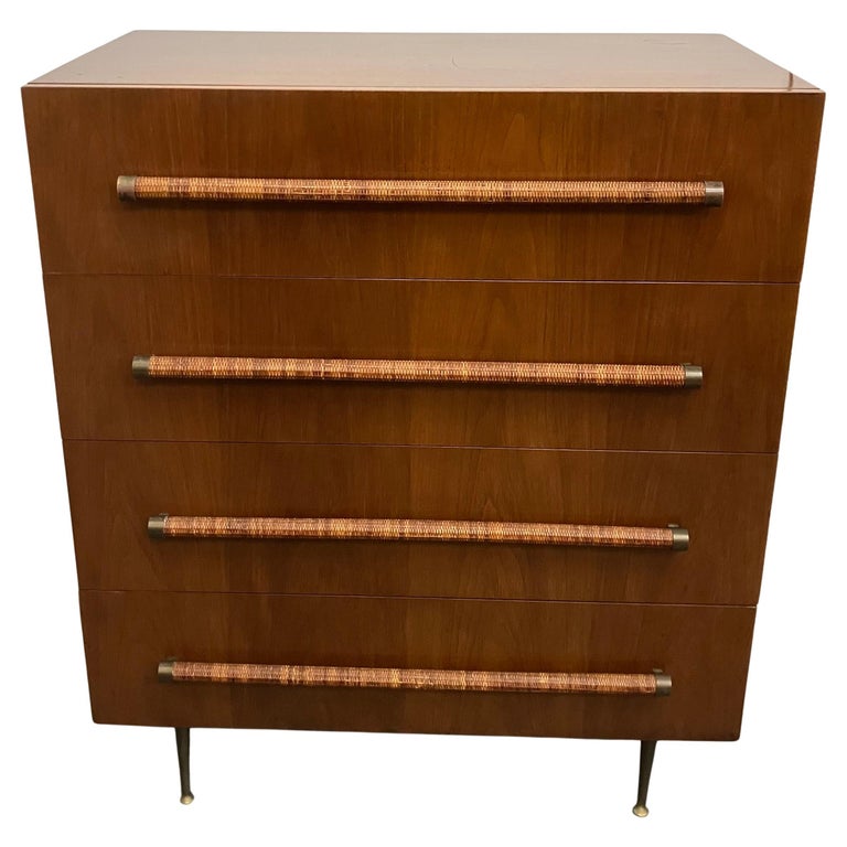 Classic T.H. Robsjohn-Gibbings for Widdicomb 4-drawer cabinet in beautiful original finish dark walnut, with brass legs, and raffia cane wrapped handles. Signed with cloth Widdicomb label. A wonderful mix of materials in an architectural design.