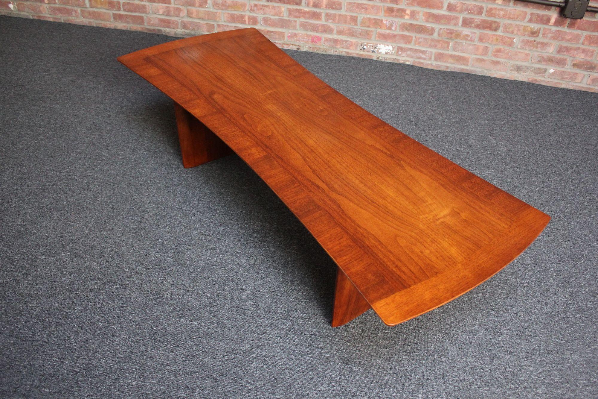 Mid-Century American Modern coffee table designed by T.H. Robsjohn-Gibbings for Widdicomb (ca. 1950s, USA). Composed of two solid walnut plinth bases supporting a 'bowtie' surface. Aesthetically pleasing with its organic form and lustrous walnut