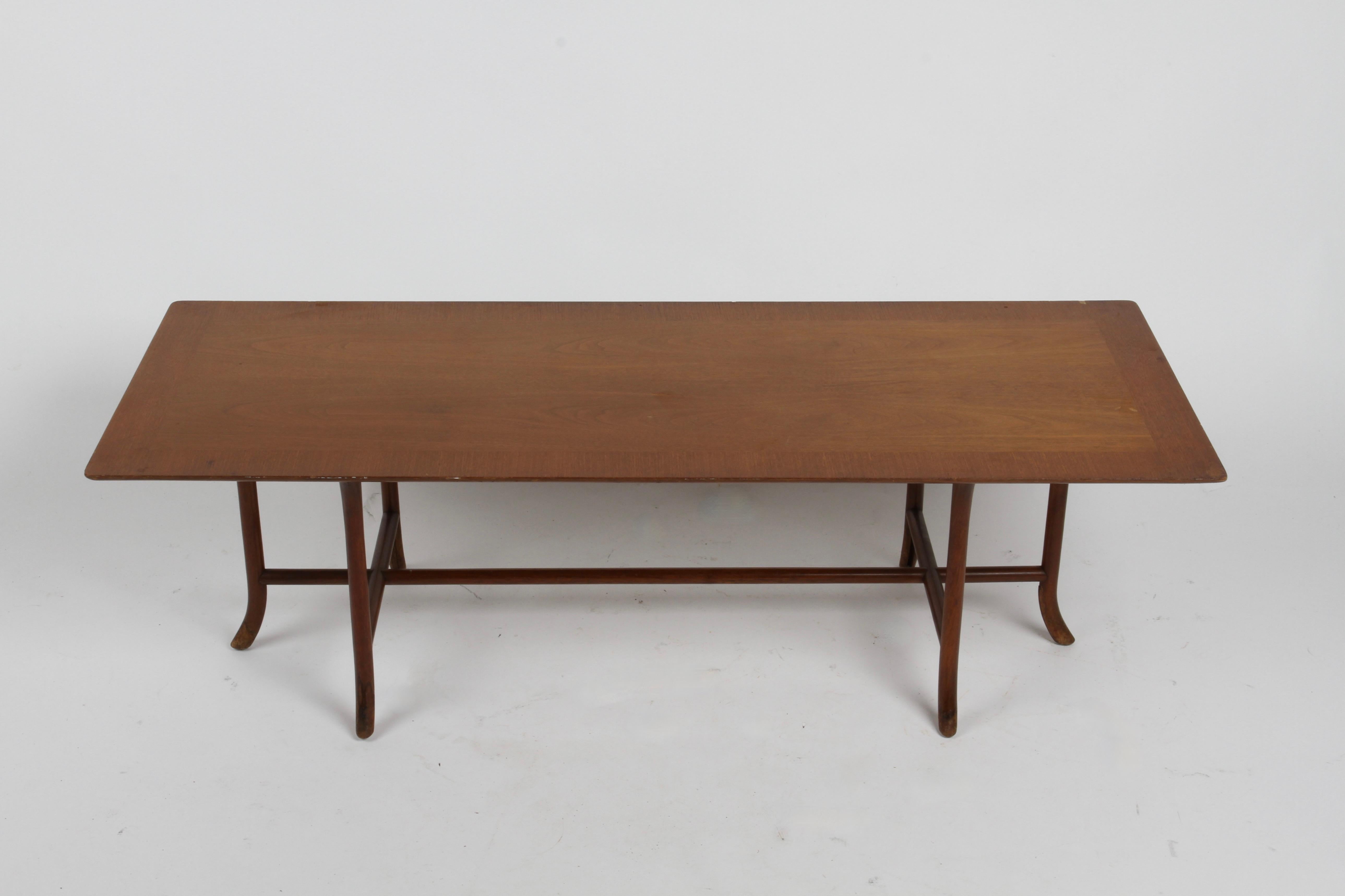 Elegant T.H.Gibbings-Gibbings for Widdicomb, this rarely seen walnut rectangular cross-trestle coffee table with sabre legs shown in original sherry finish. Walnut book matched veneer top with edge banding, on classic Gibbings sabre legs. Shown in