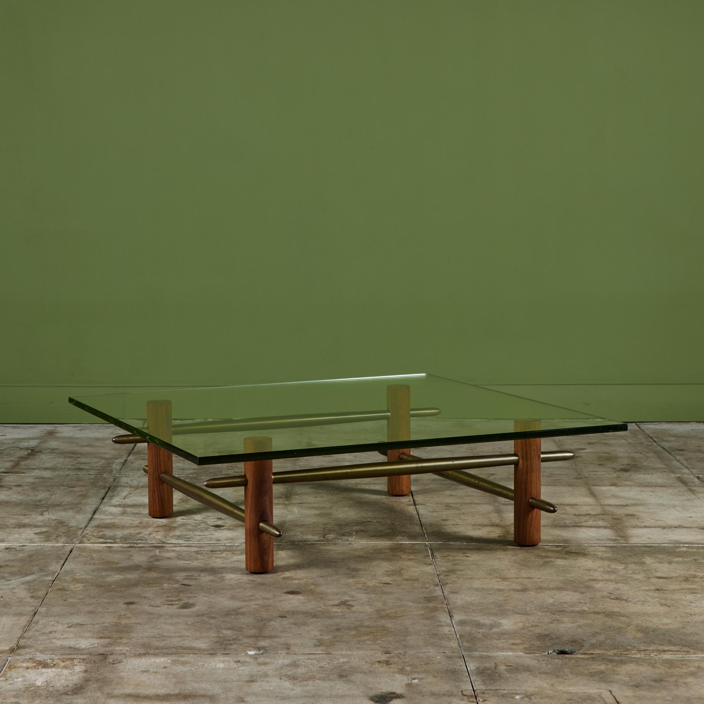 Table basse ancienne de T.H Robsjohn Gibbings, fabriquée par Widdicomb vers les années 1950, États-Unis. Cette table carrée à plateau en verre présente le verre épais vert d'origine, des pieds en noyer et quatre brancards en laiton massif qui
