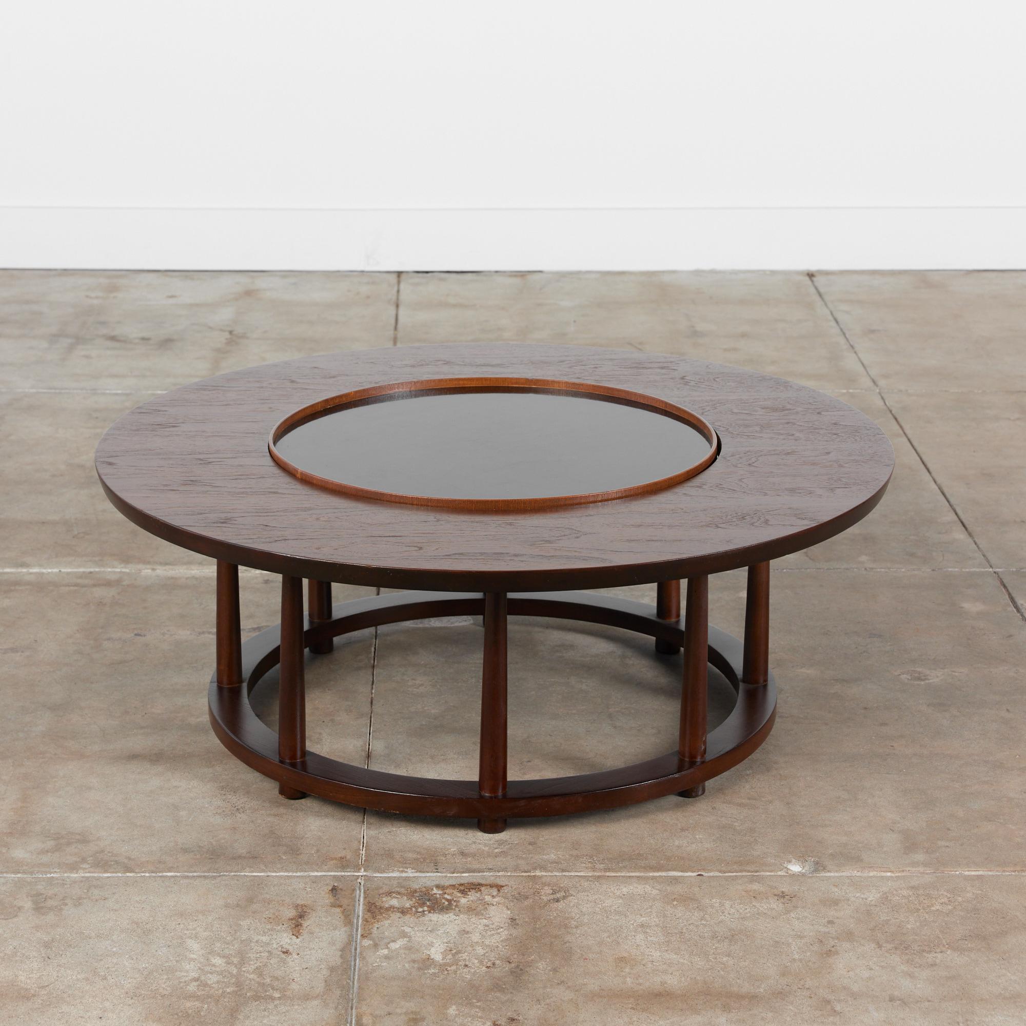 Coffee table by T.H Robsjohn Gibbings, manufactured by Widdicomb circa 1950s USA. This beautiful walnut table features a round table top with an inset black laminate lazy Susan in the middle of the table. It is supported by a circular base and eight