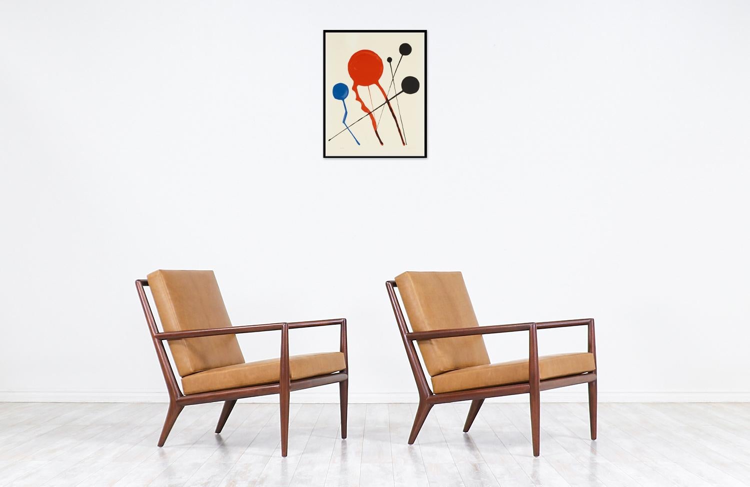 Elegant modern lounge chairs designed by T.H. Robsjohn-Gibbings in collaboration with the famous Widdicomb Furniture company in the United States during the 1950s. These midcentury ergonomic lounge chairs feature a solid walnut wood frame with