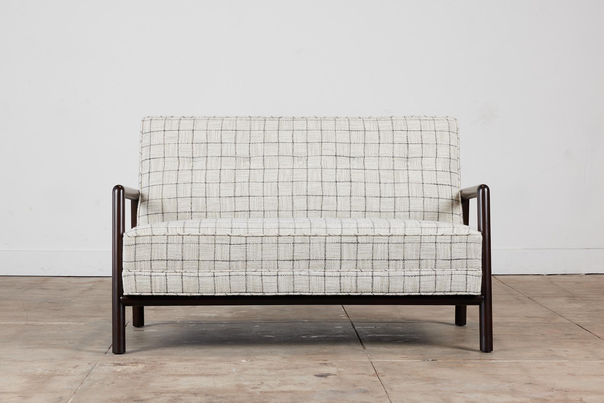 Loveseat by T.H Robsjohn Gibbings, for Widdicomb c.1950s USA. This sofa features rounded stained beech wood frame with armrests. The cushions have been newly reupholstered in a gray window pane wool blend fabric with a tufted back