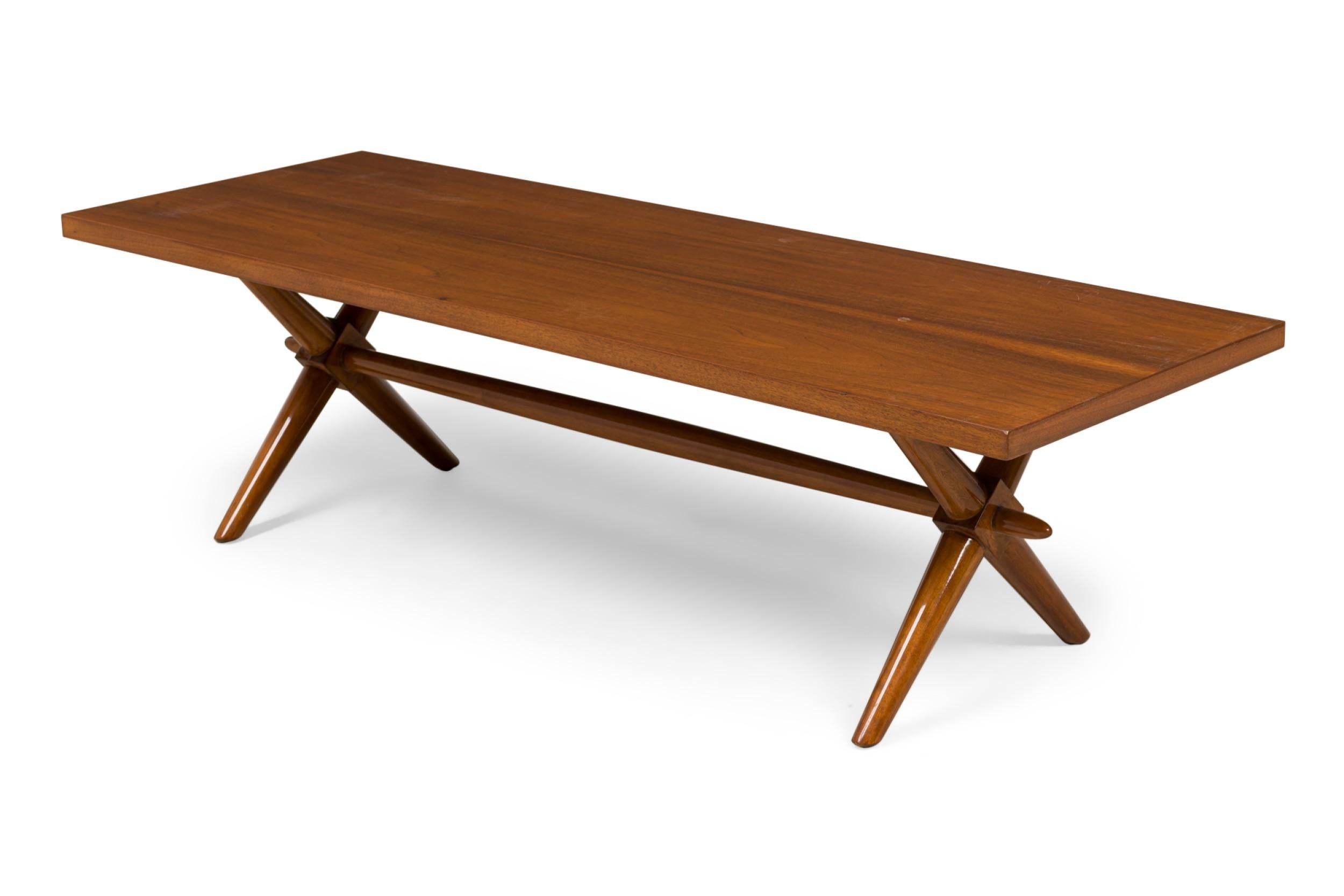Mid-Century American Modern walnut low coffee table featuring a rectangular top over an X-form base composed of sculptural, tapering legs and stretcher. (T.H. ROBSJOHN-GIBBINGS)
