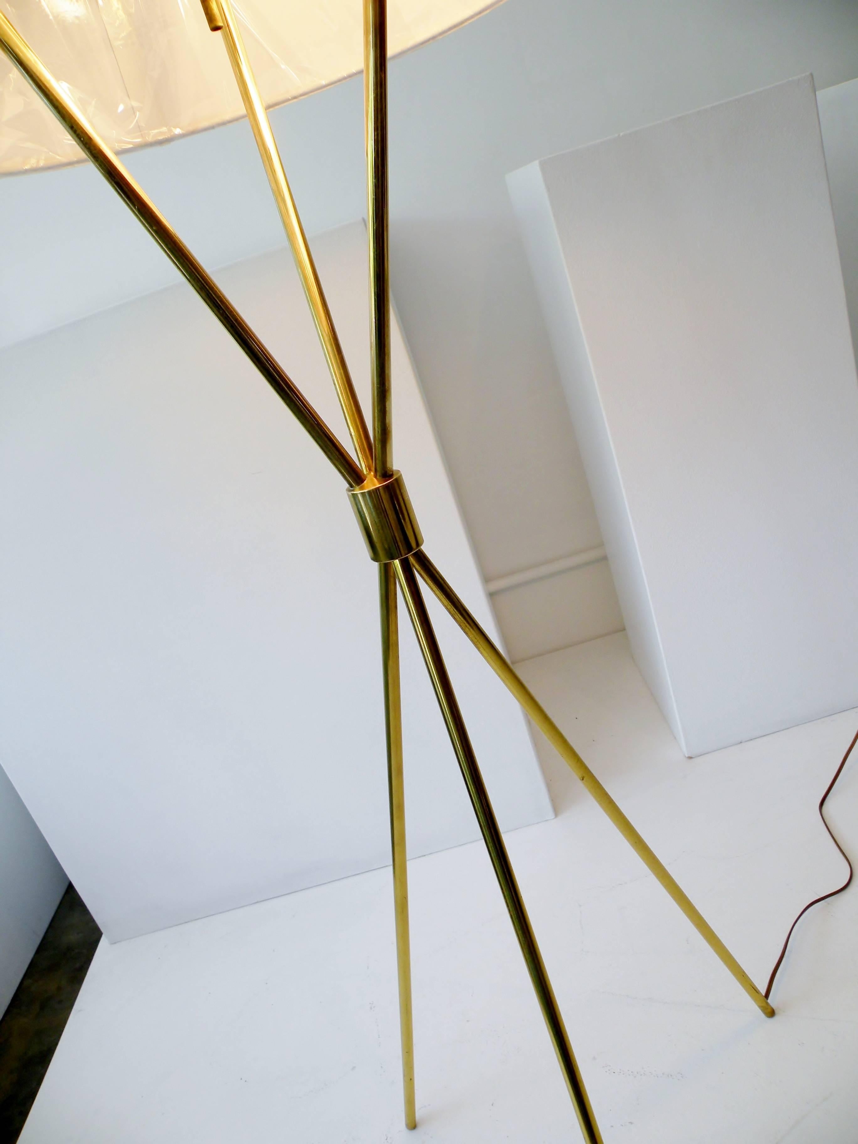 The iconic T.H. Robsjohn-Gibbings designed tripod floor or reading lamp for Paul Hansen Lighting, New York. Fine quality brass construction and marked Paul Hansen to top metal diffuser shade. Rewired with new custom-made off-white linen shade,