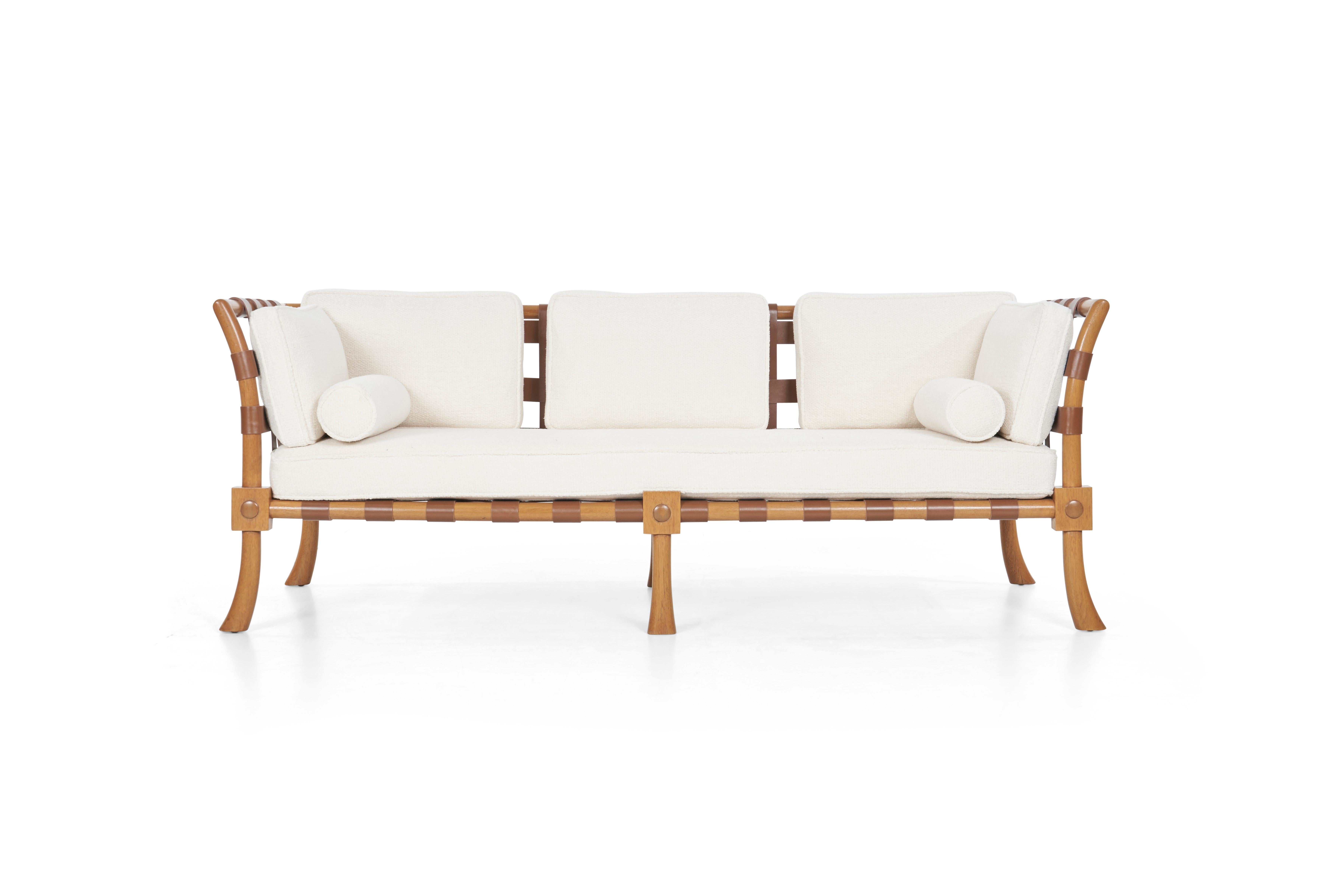 Robsjohn-Gibbings custom sofa, solid bleached mahogany, exposed leather belting straps support cushions.
Professionally restored mahogany wood, replaced leather straps, reupholstered with great plains nubby wool fabric.