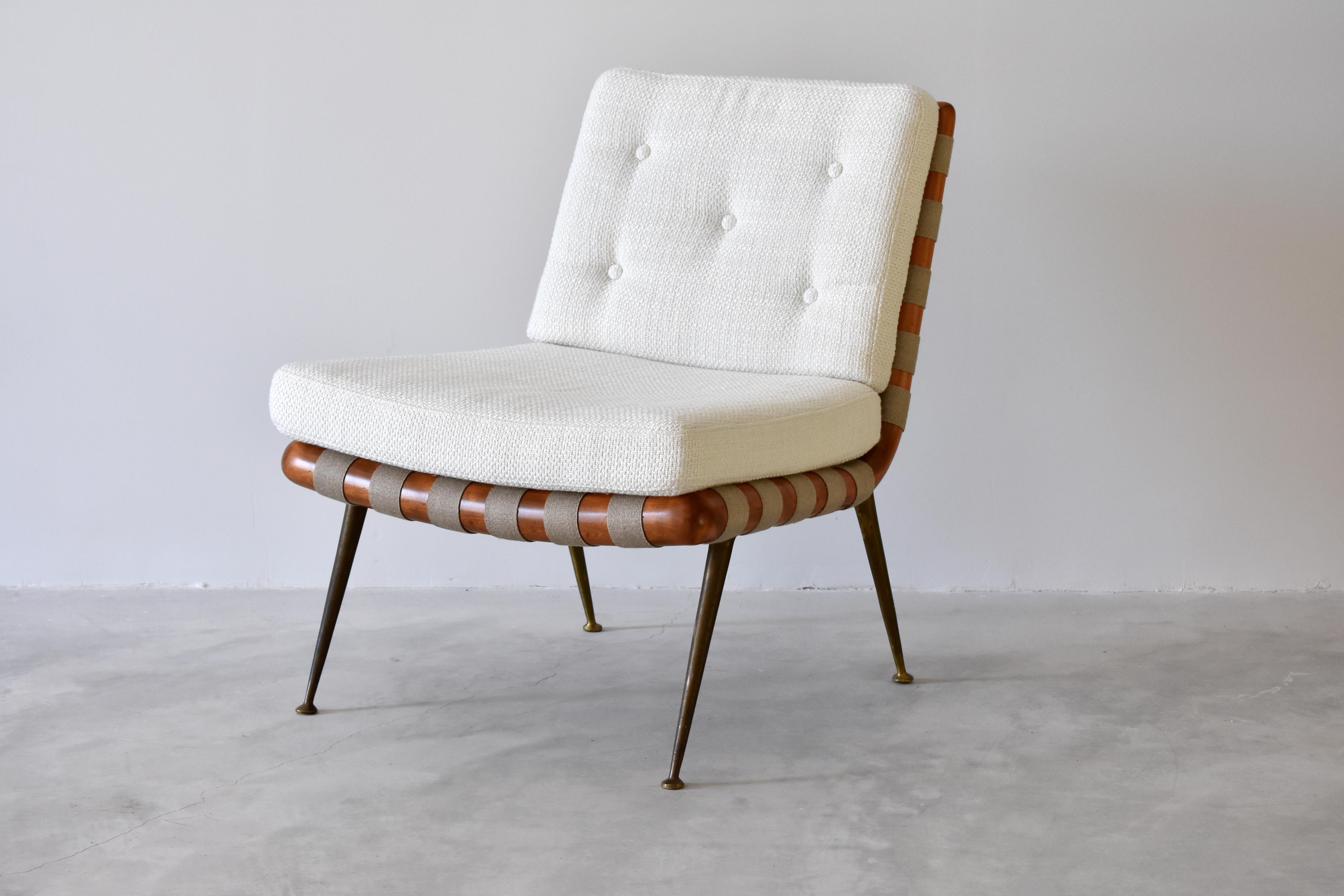 A rare lounge / cocktail / slipper chair designed by T.H. Robsjohn-Gibbings. The dark walnut and straps provide an elegant contrast to the off-white fabric and brass legs. Manufactured by The Widdicomb Furniture Company.

Work partly lends its