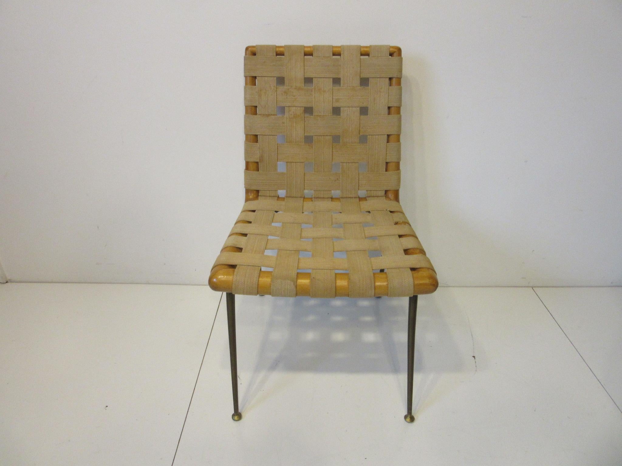 A cotton webbed side chair with solid mahogany sculptural frame and cast brass legs by iconic Mid Century designer T.H. Robsjohn-Gibbings for the Widdicomb Furniture company noted for their well crafted pieces. A great chair for a desk or a special