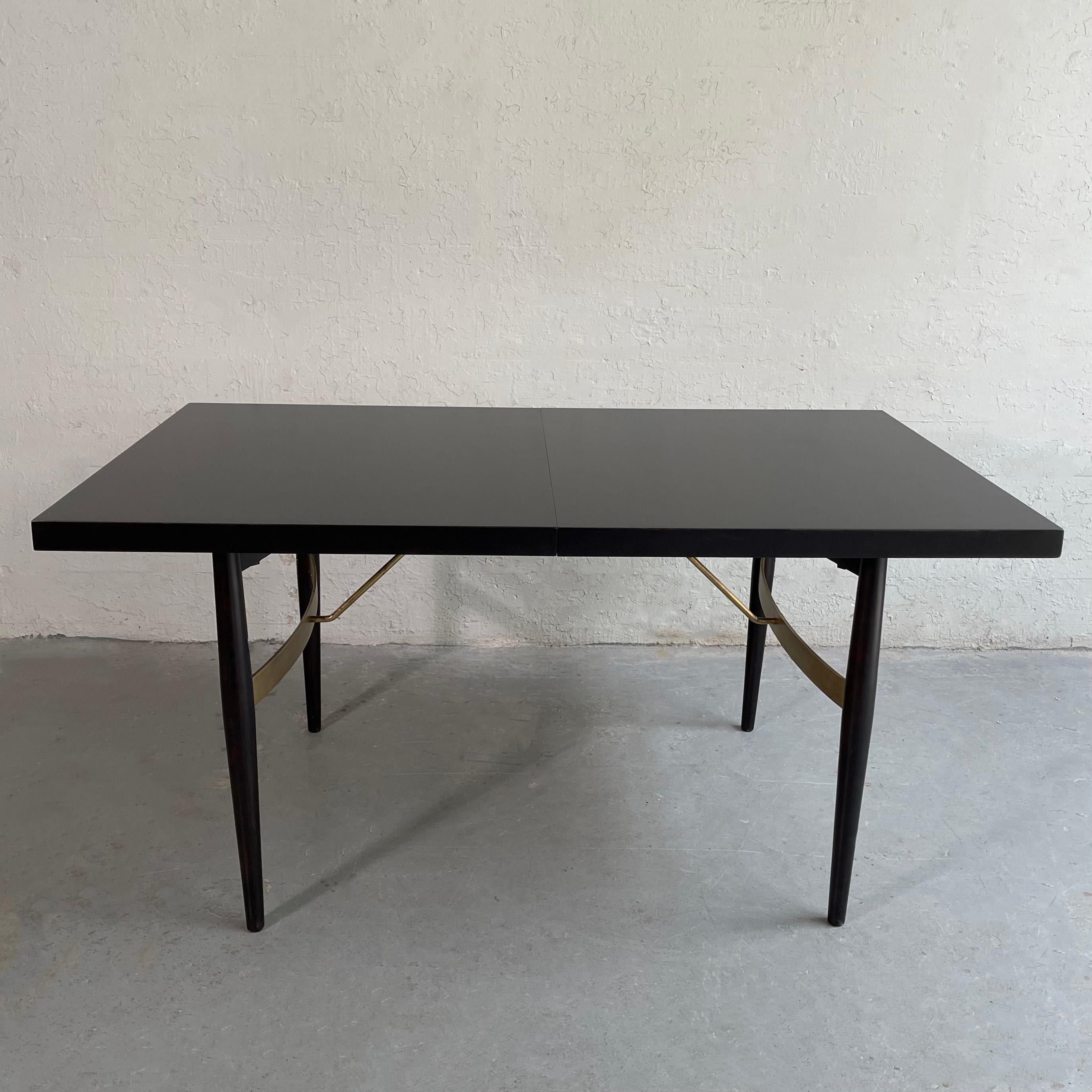 Midcentury modern, dining table in the style of T.H. Robsjohn-Gibbings features an 2 inch thick, ebonized mahogany top with maple legs and brass bracing. 