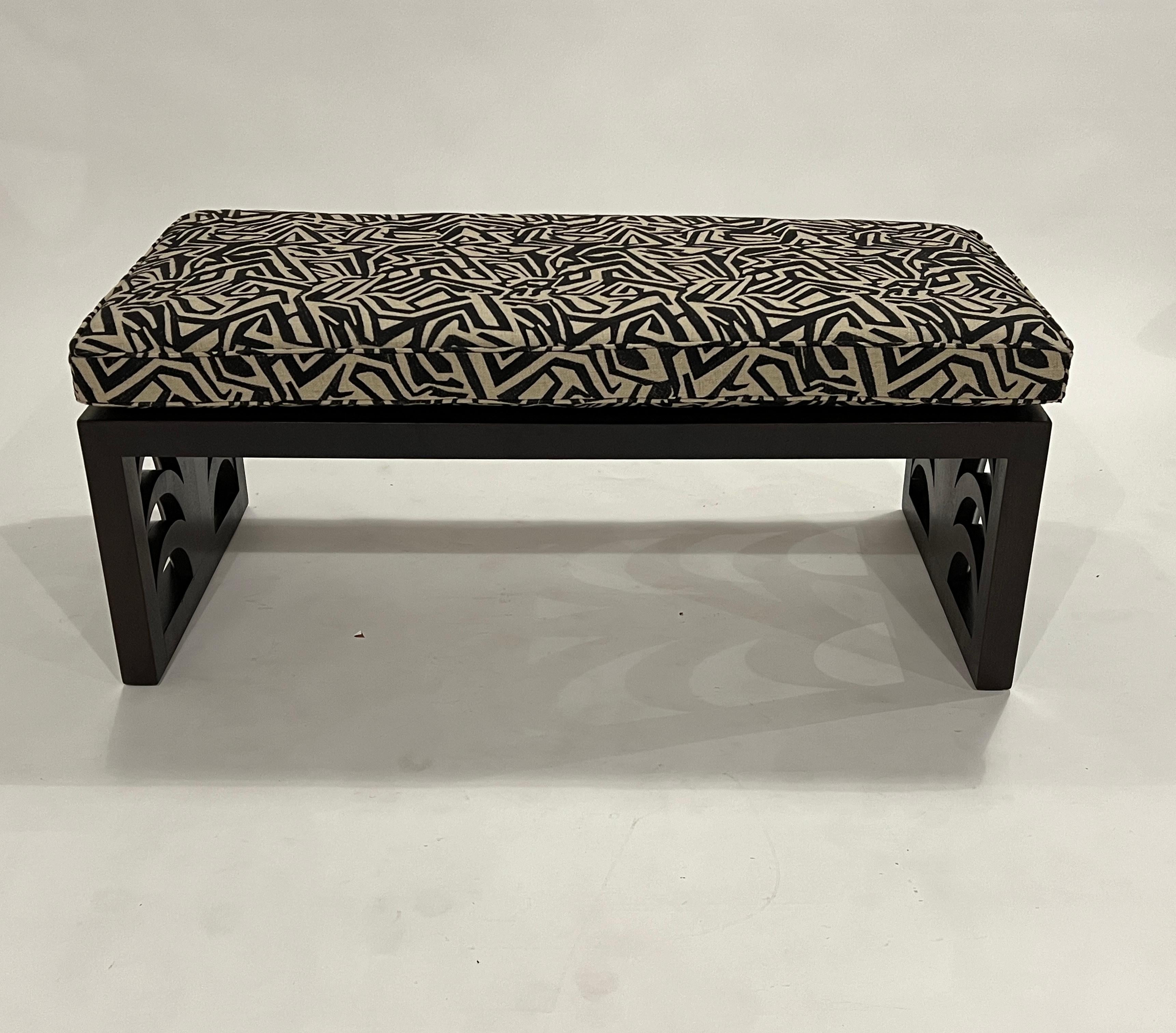 Mid-century mahogany coffee table designed by T.H. Robsjohn Gibbings for Widdicomb. This cocktail table design features a palm leaf motif on the ends and has been reinvented to include a bench cushion upholstered in a tribal pattern of cream and