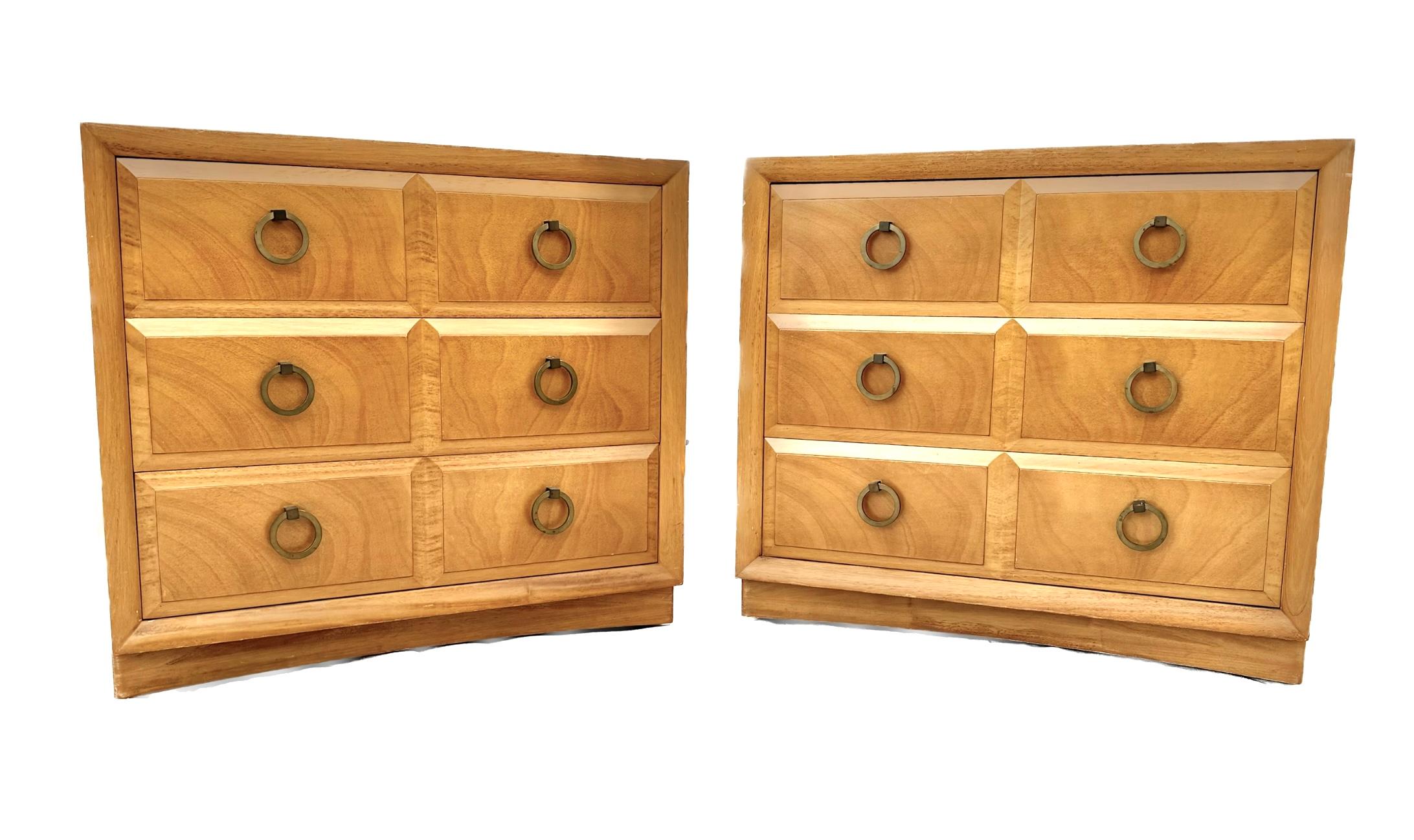 Stunning pair of mid-century three-drawer bedside tables / chests in walnut by T.H. Robsjohn-Gibbings for Widdicomb. Beveled drawer fronts with brass ring pulls, dovetail joinery, and Widdicomb label affixed inside top drawer. Iconic American mid