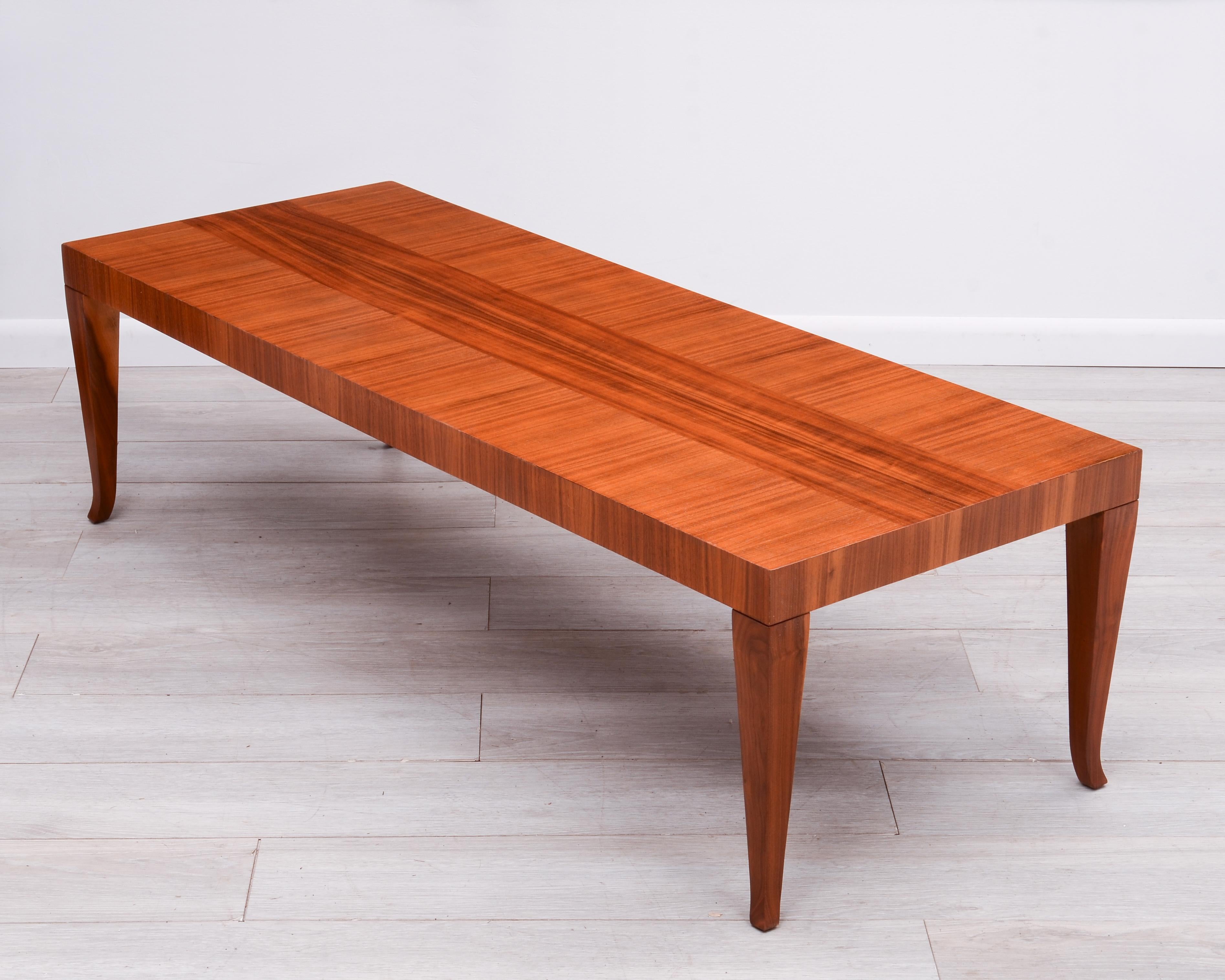 A saber leg coffee table designed by T.H. Robsjohn-Gibbings for Widdicomb and made in 1957. The table top features contrasting bands of book matched walnut. Like all T.H. Robsjohn-Gibbings designs the table is incredibly well made with attention to