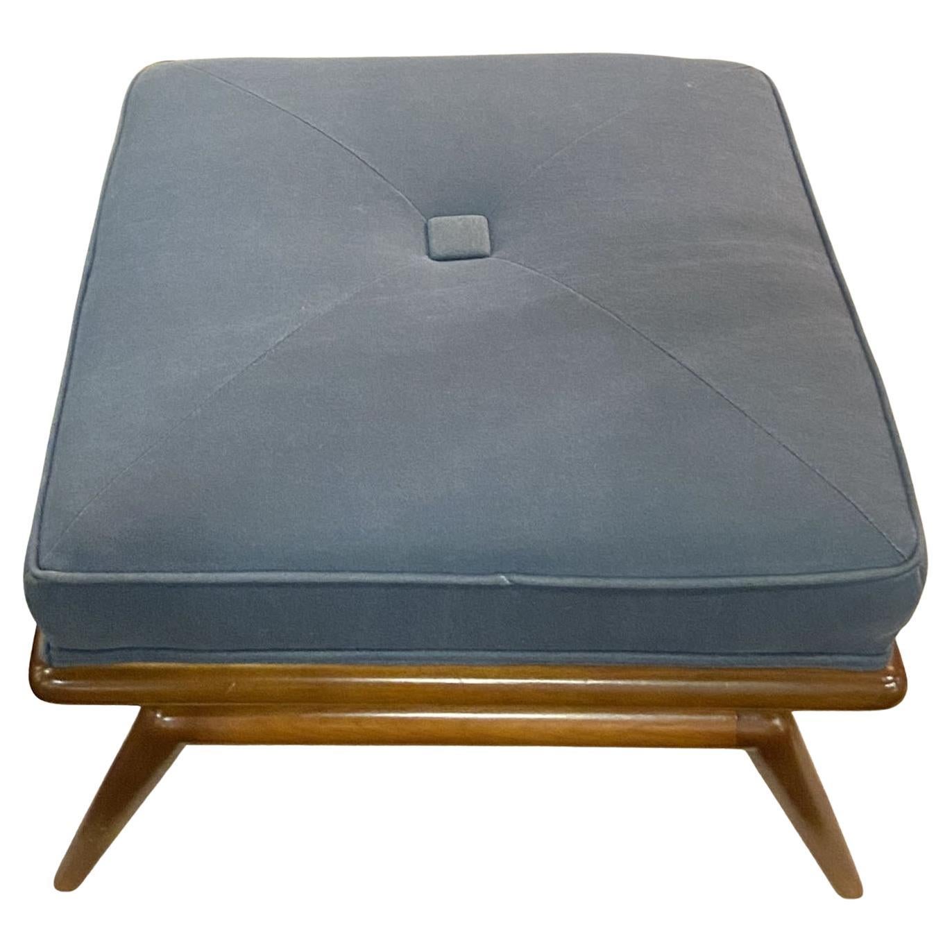 Fußhocker aus Ottomane des legendären T.H. Robsjohn-Gibbings. U.S.A., Widdicomb Furniture Co, ca. 1955, Vereinigte Staaten.
Stromlinienförmiges Gestell aus massivem Nussbaumholz, komplett überarbeitet und neu gepolstert mit mausgrauem Wollfilz. Der