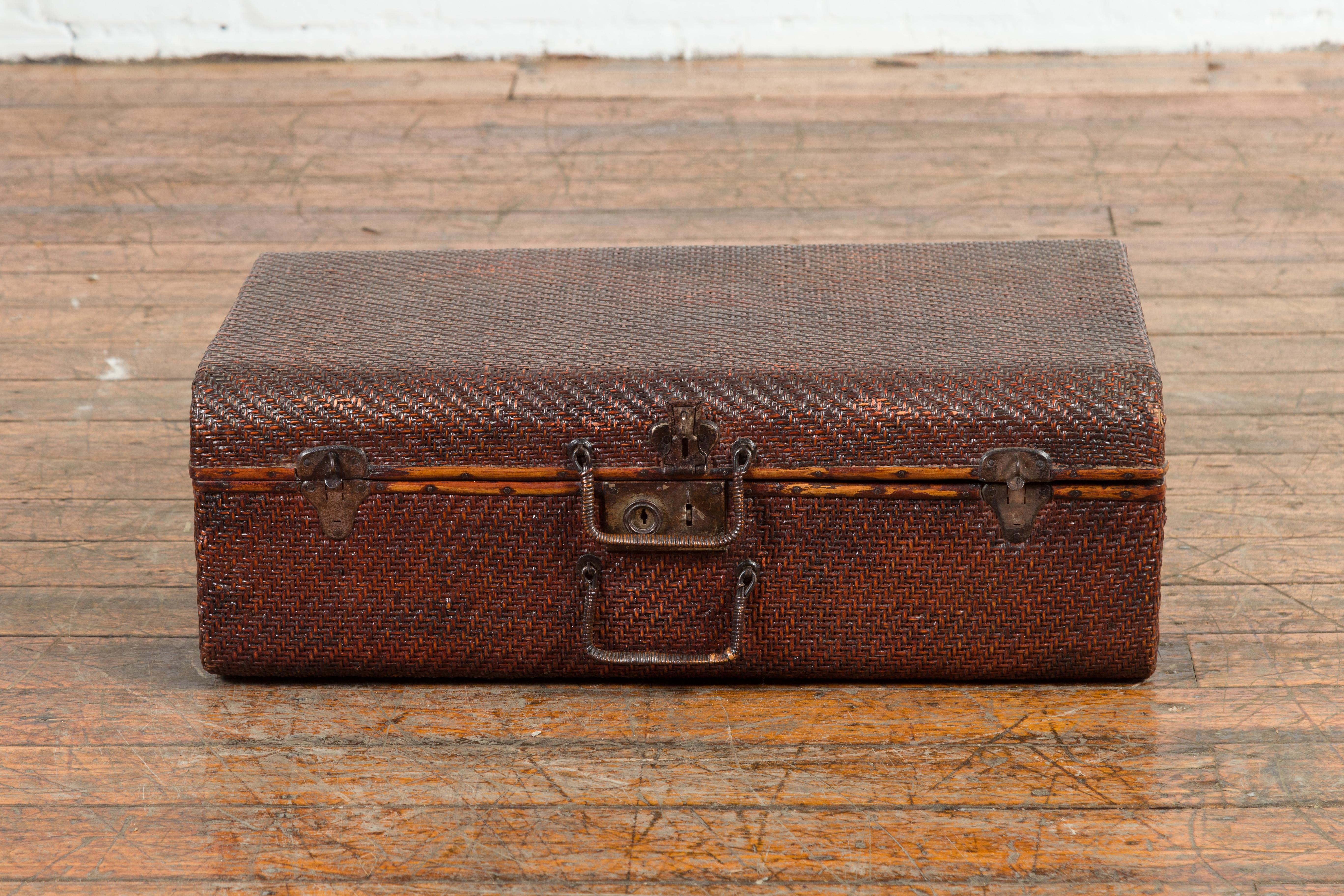 An antique Thai rattan over wood carrying case from the 19th century, with scroll-painted interior. Created in Thailand during the 19th century, this antique carrying case features a rattan bound exterior accented with metal hardware. The lid opens