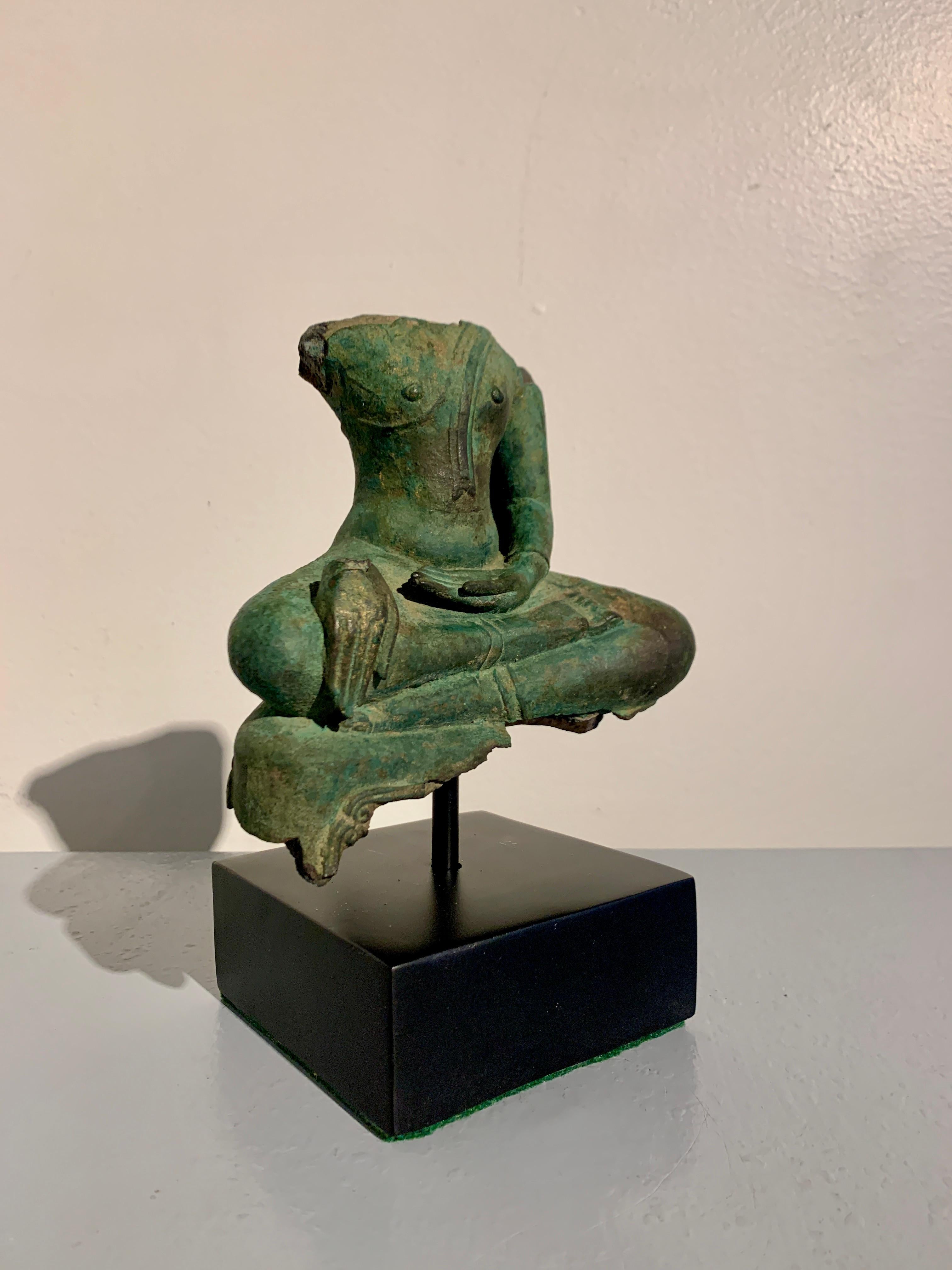 An enigmatic and ephemeral Thai cast bronze fragment of a seated Buddha, Sukhothai Kingdom, circa 15th/16th century, Thailand.

The fragment depicts the historical Buddha, Shakyamuni. The upper half of his torso, from the shoulders up, is missing,