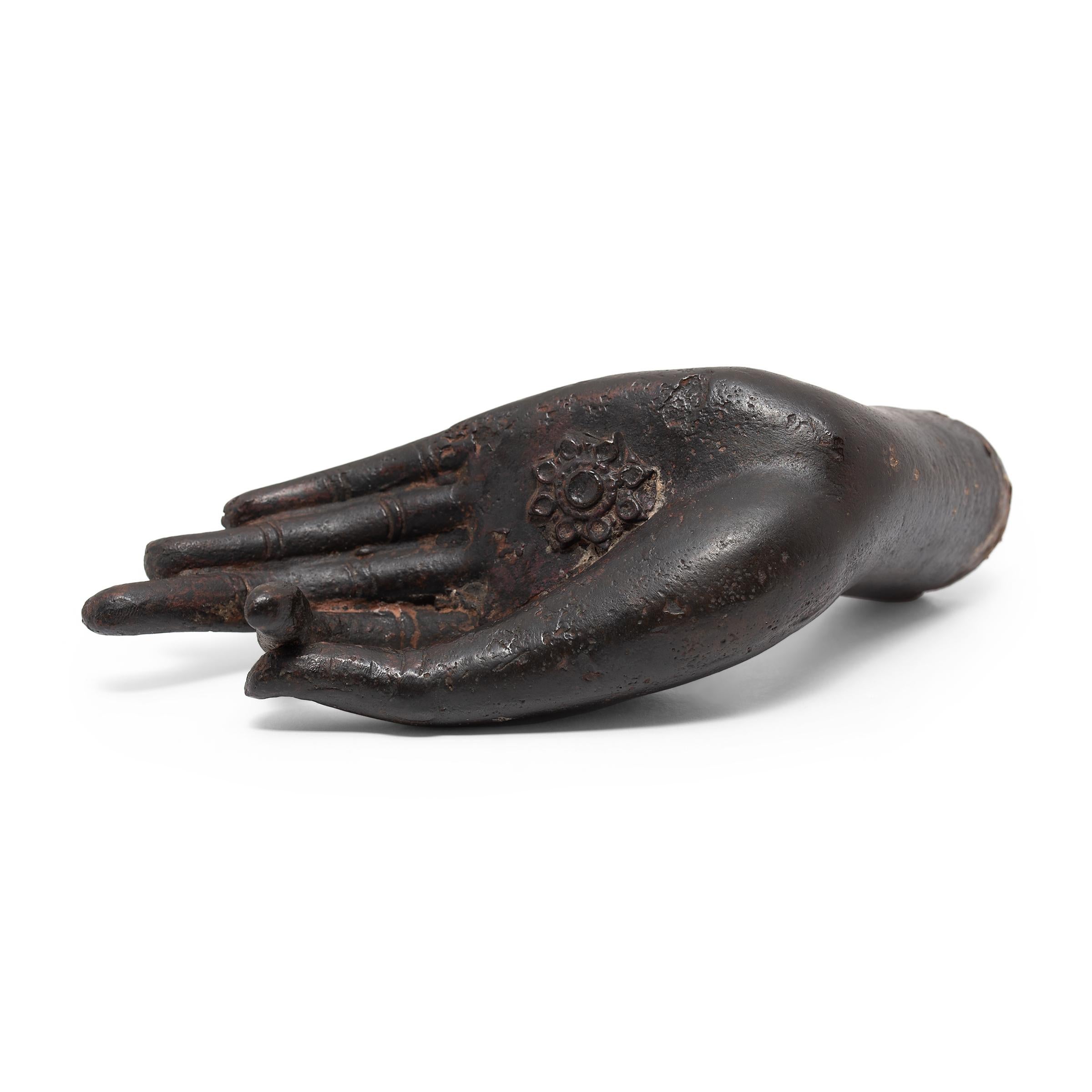 This 19th-century Buddha's hand sculpture from Thailand is finely cast of bronze with lifelike features and a beautifully dark patina. The slender left hand is held gracefully in vitarka mudra, a part of the gesture of teaching and intellectual