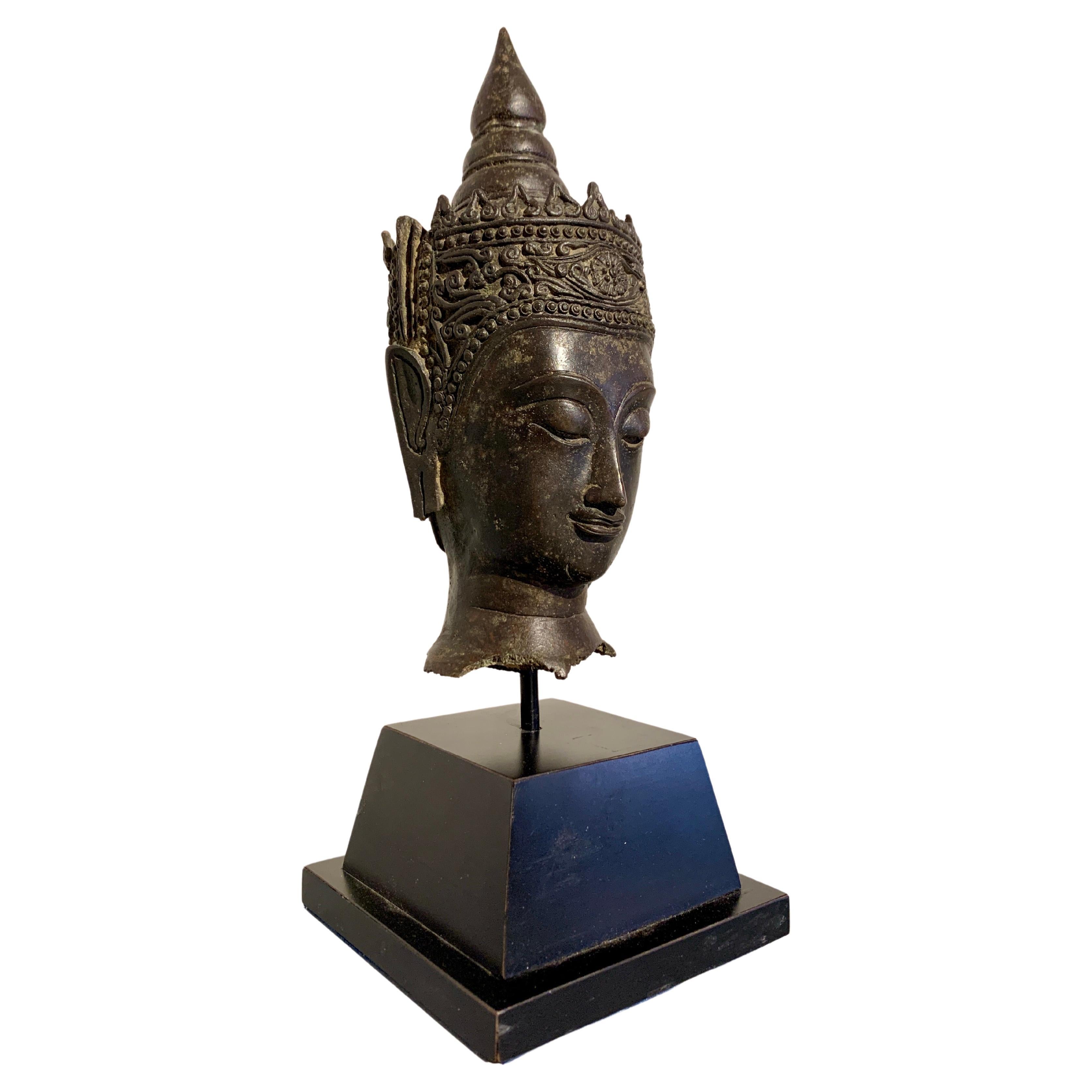 An enchanting Thai cast bronze head of a crowned Buddha, Ayutthaya period, 17th century, Thailand.

The Buddha's face is simply gorgeous, with elegant, well defined features. The Buddha looks out from downcast eyes under high arched brows. The