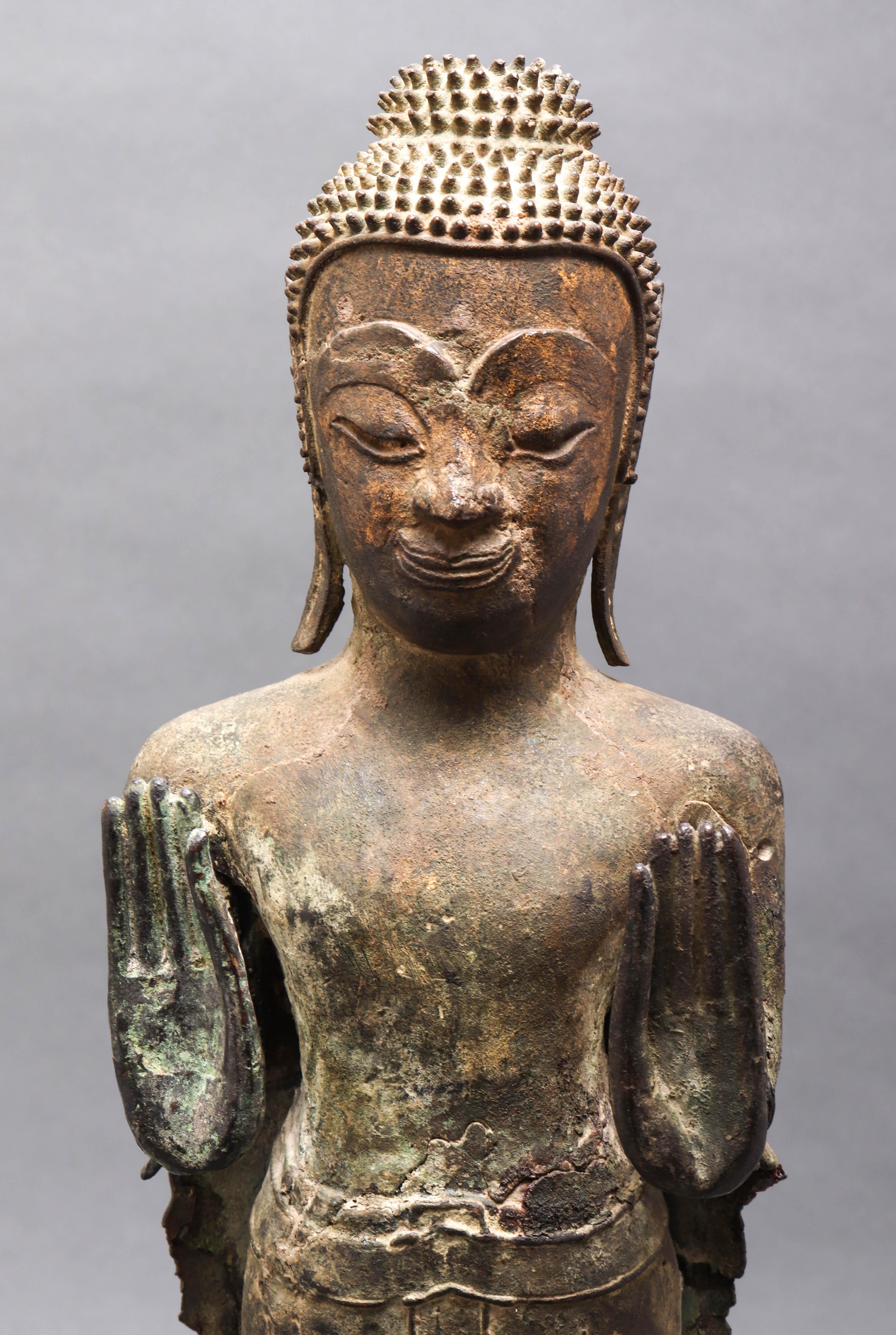 Thai bronze figure of a standing Gautama Buddha. The piece dates from the circa 18th-19th century, with both hands held up in the double abhaya mudra position and standing with feet together. Mounted o a wood plinth base. In great antique condition
