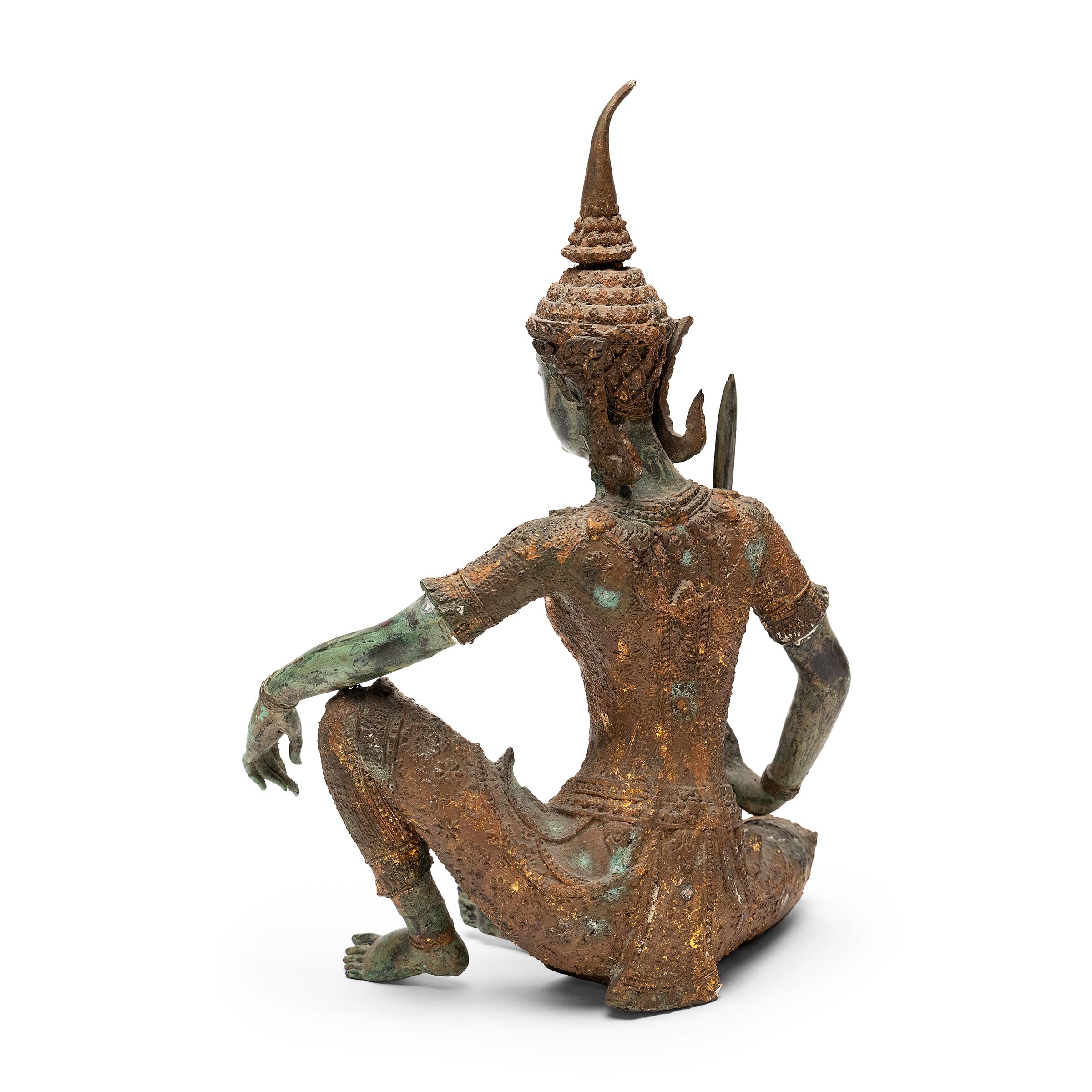 Coulée avec des proportions gracieuses et des détails complexes, cette figure en bronze d'un guerrier princier est un bel exemple du travail traditionnel du métal en Thaïlande. La figurine en bronze coulé représente un guerrier mythique vêtu d'un