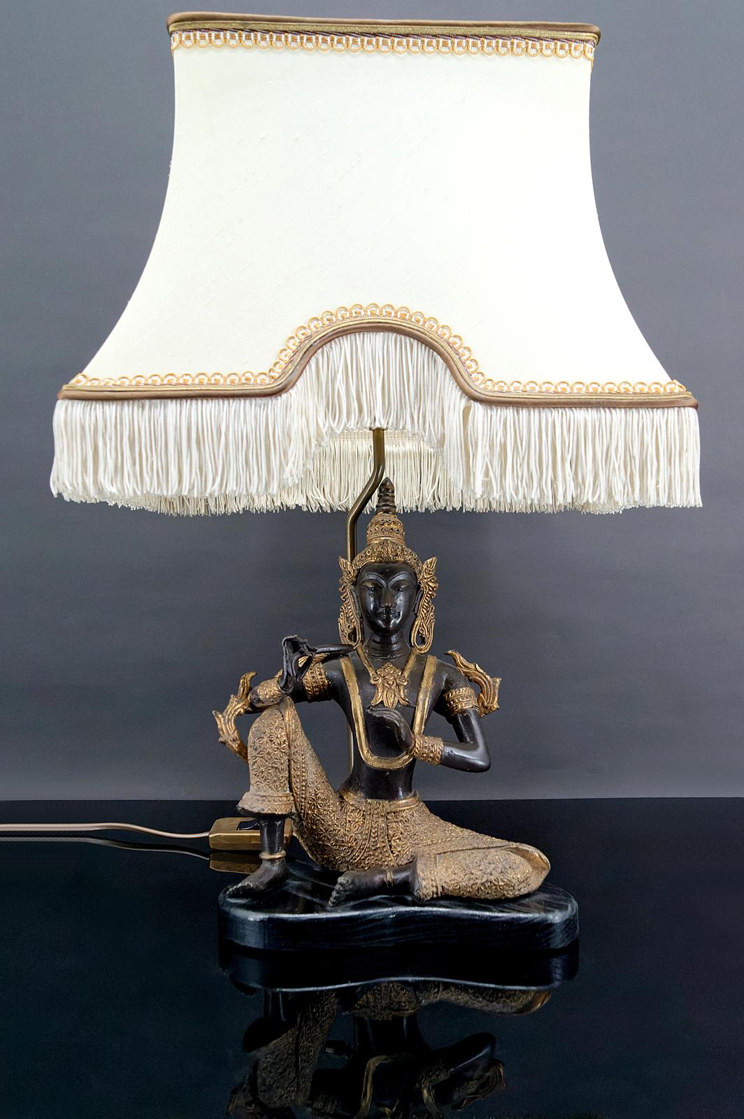 Thai bronze with double black and gold patina mounted as a lamp on a blackened wooden base.
Very beautiful pagoda lampshade.
Beautiful work by a French decorator from the 1960s, in the style of the productions of Maisons Charles and Jansen.

In very