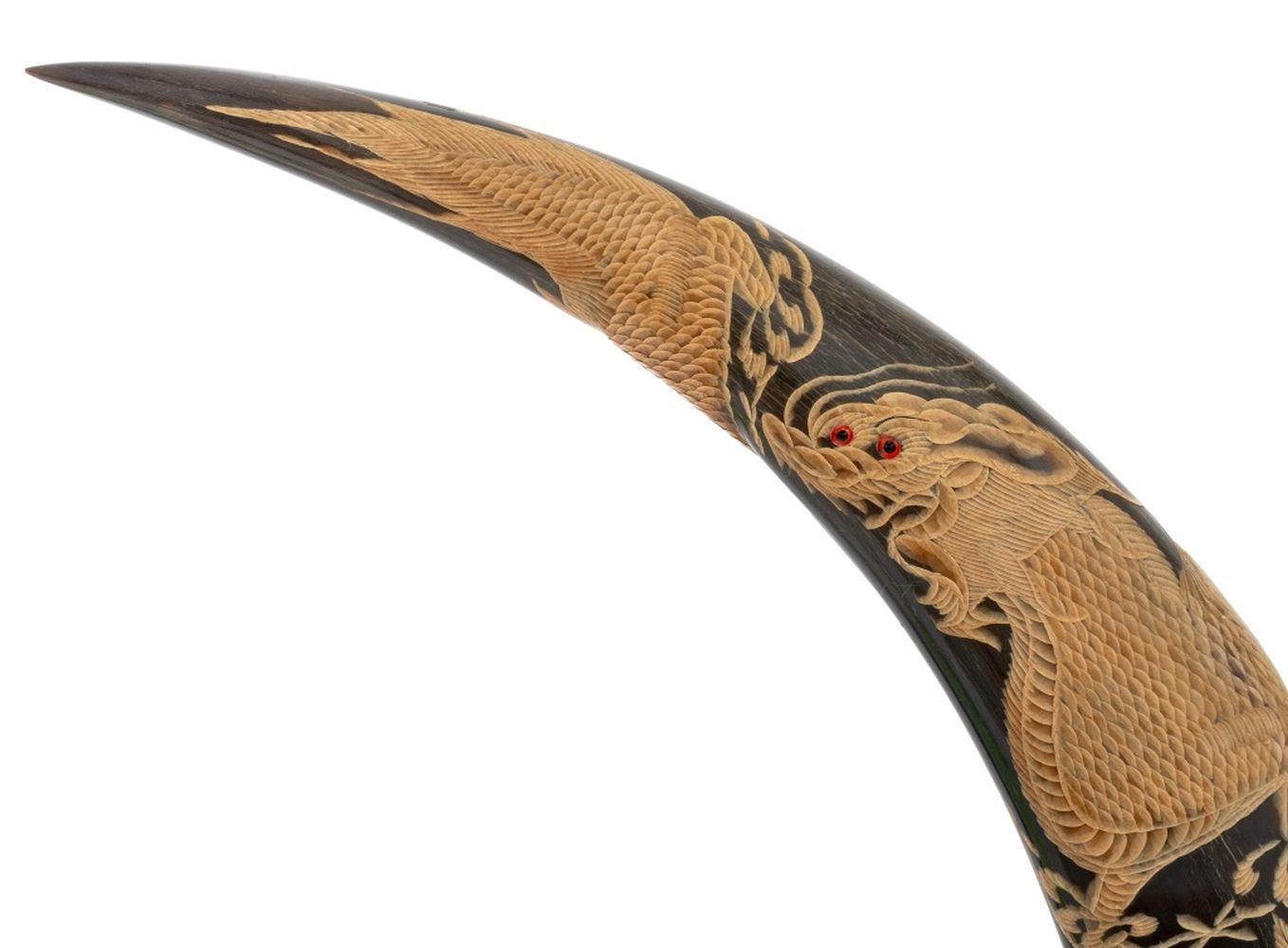 Pareja de esculturas tailandesas talladas en cuerno de búfalo, con motivos de dragón, pájaro y tigre, montadas sobre bases de madera. Total de cada una: 23,25