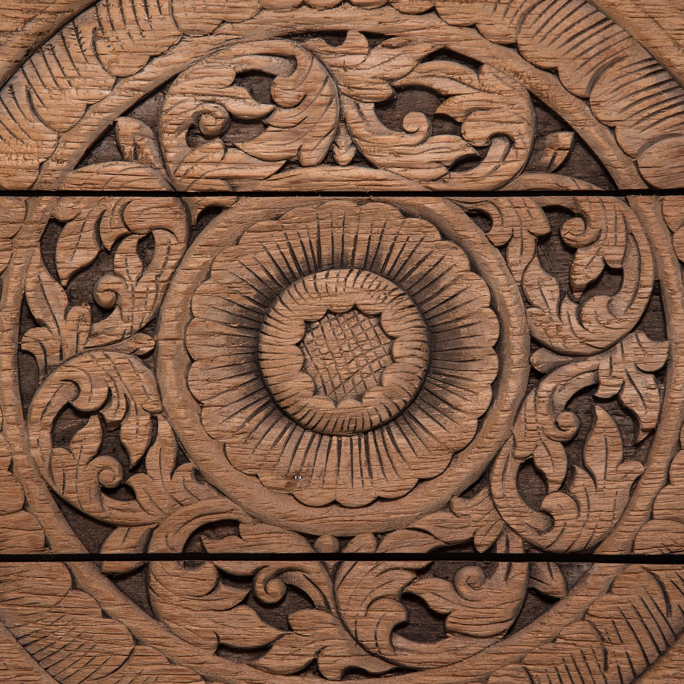 Worked from reclaimed teak boards, this large, seven-board panel is hand-carved in relief with a decorative mandala design in the style of Thai or Balinese fretwork screens. Concentric circles with floral motifs radiate from a central lotus blossom,