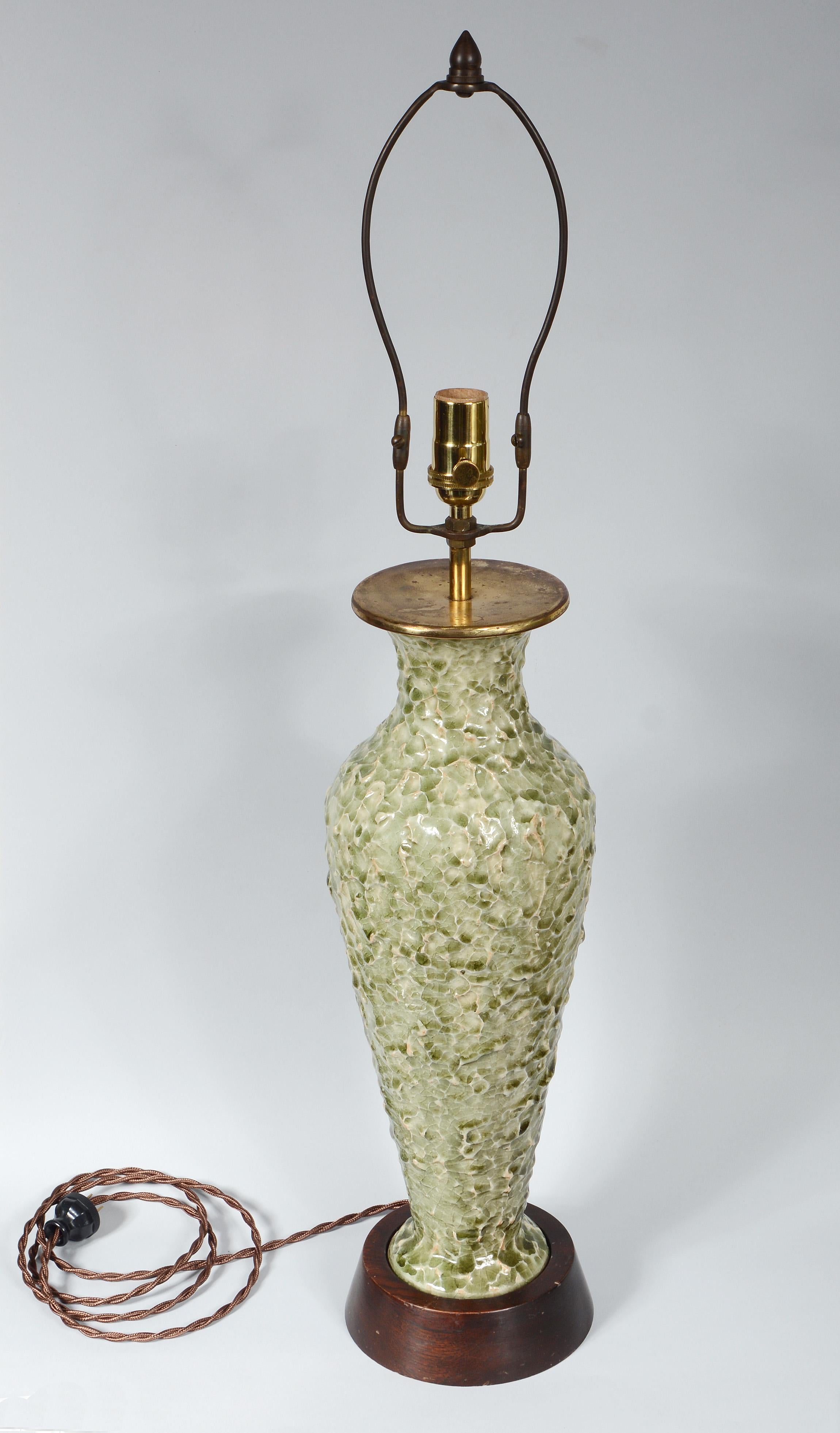 Table lamp produced by Thai Celadon in Bangkok. This lamp has an unusual textured surface. The lamp has been rewired and has a new three way socket. The base is mahogany. The lamp is 32 1/2