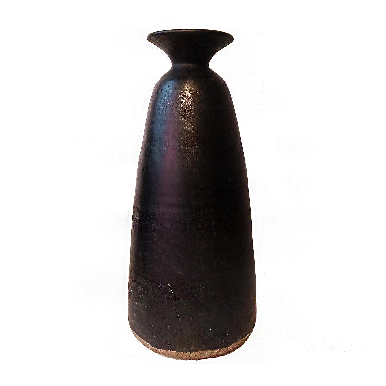 A tall ceramic vase / urn with black glaze. Hand-crafted in Thailand, in the tradition of antique Thai earthenware. Circa 1970. 

Sawankhalok, one of the main centers of ancient Thai ceramics, was known for its green celadon glaze. But it also