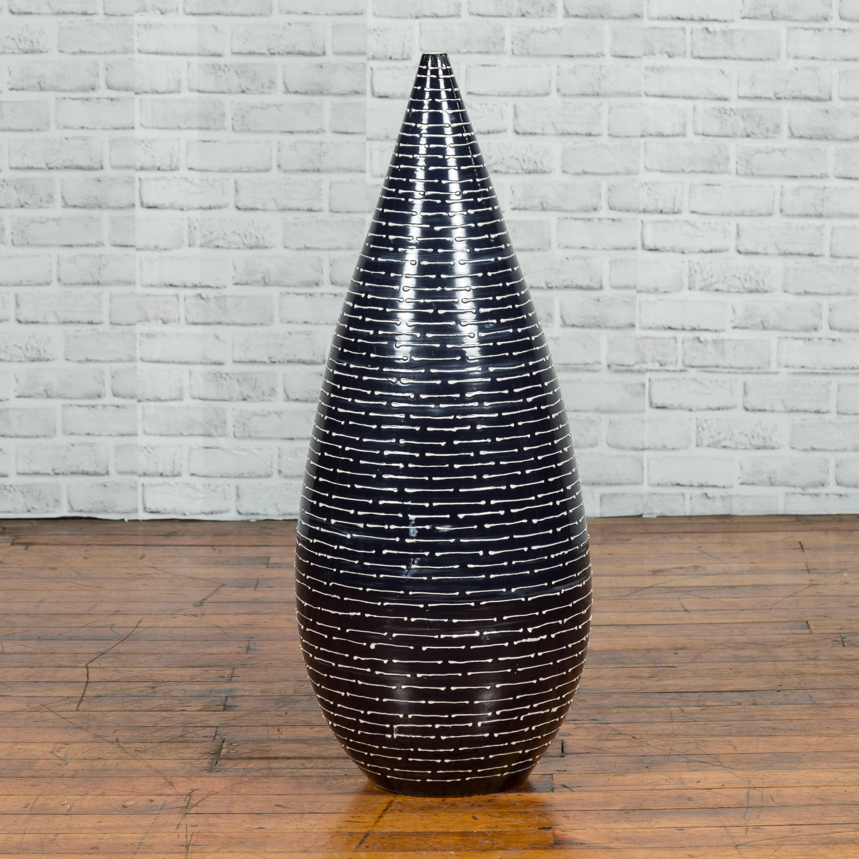 A Thai Chiang Mai contemporary ceramic black and white vase from the Prem collection with tapering lines. Charming our eye with its sleek lines, this vase was born in Chiang Mai, northern Thailand. The piece showcases a tapering body, adorned a
