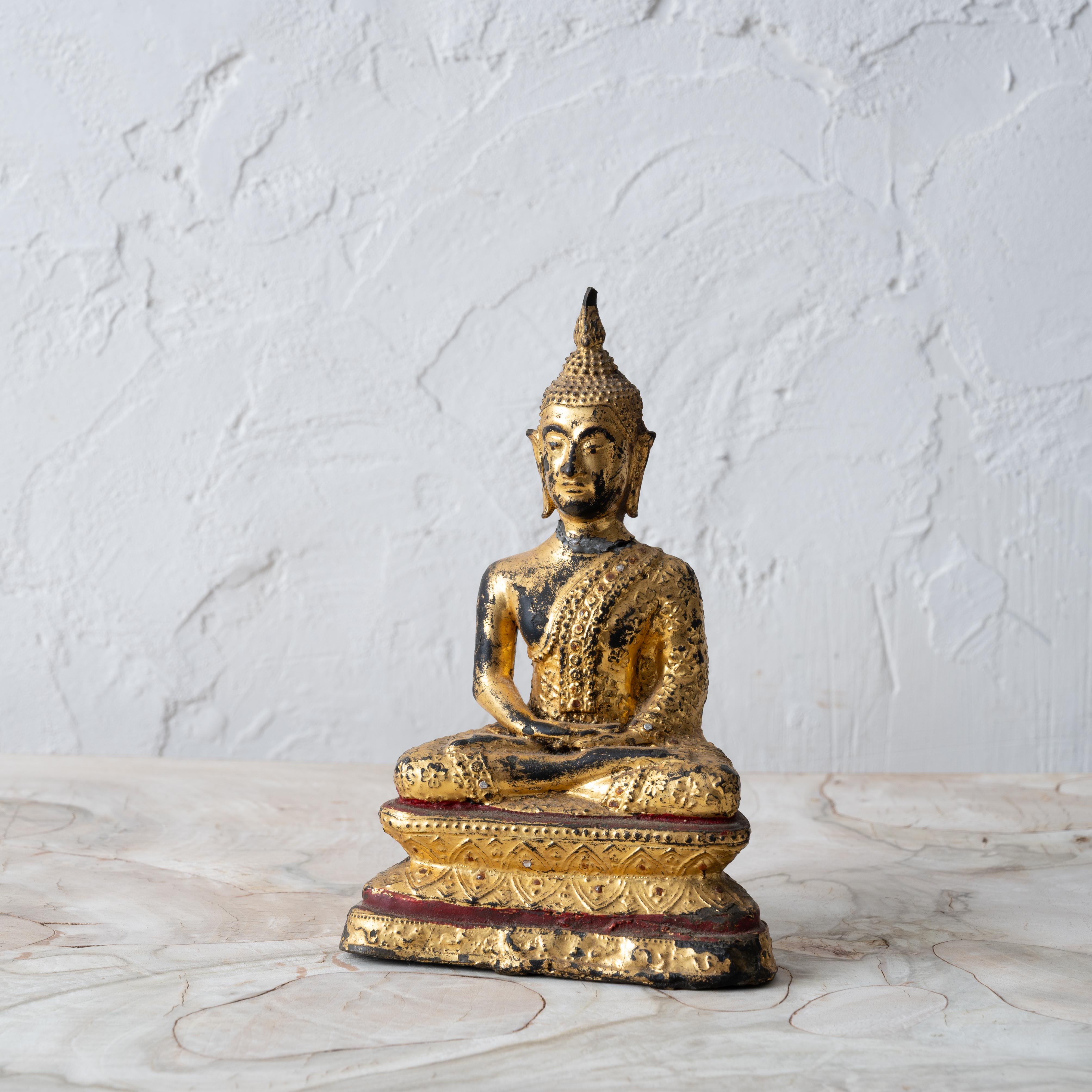 A Thai gilt bronze seated buddha, 19th Century.

4 ½ inches wide by 2 ½ inches deep by 7 inches tall

