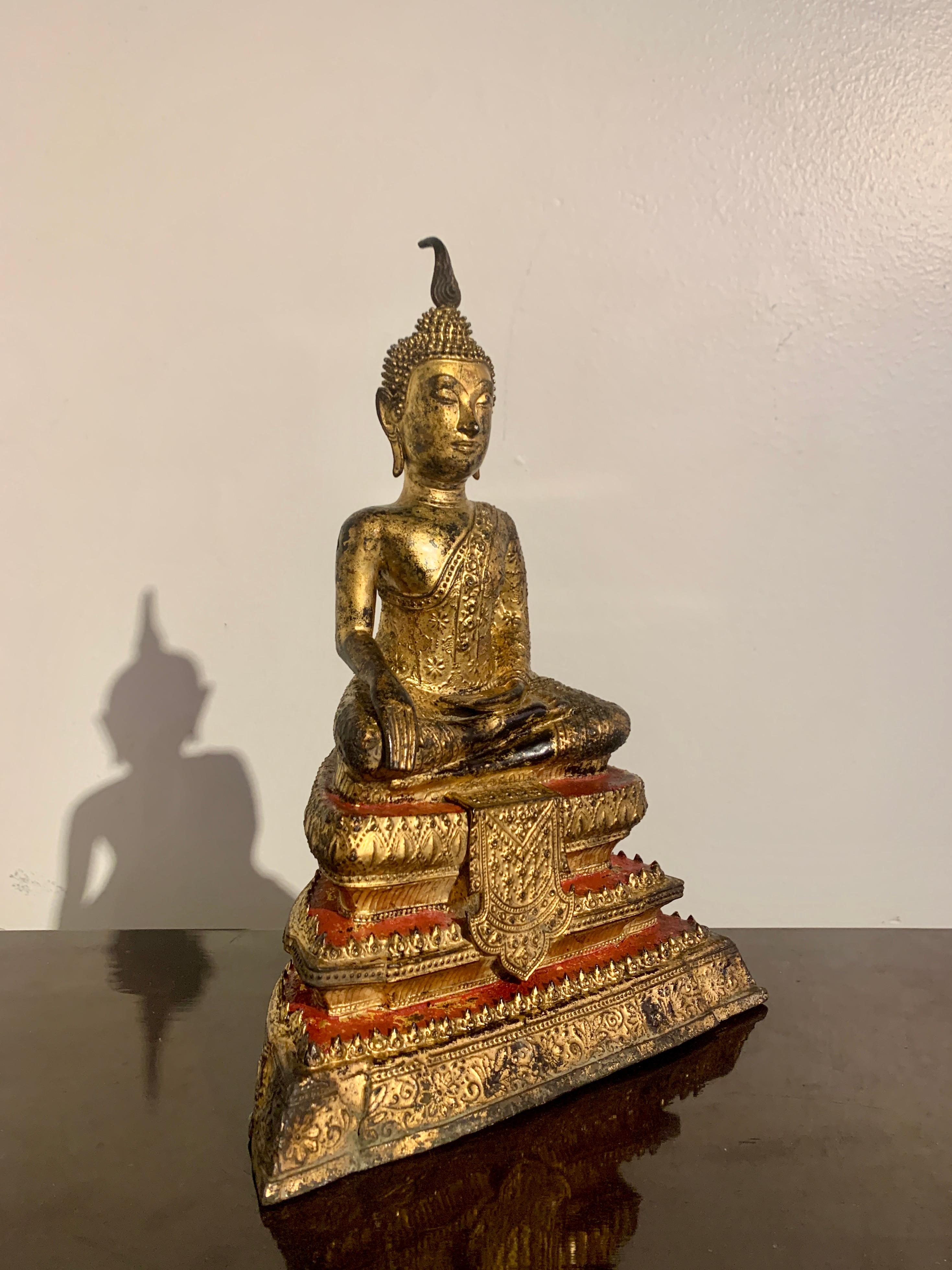 Ravissante figurine thaïlandaise en bronze laqué et doré représentant le Bouddha historique, Shakyamuni, en Maravijaya, période Rattanakosin, début ou milieu du XIXe siècle, Thaïlande. 

Le Bouddha est représenté dans l'attitude de Maravijaya, la