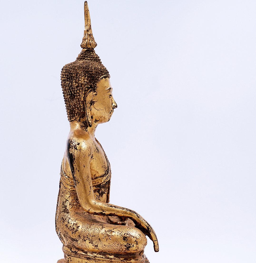Thai gilt bronze figure of a seated Buddha, depicted with legs crossed in the virasana position with the right leg resting on the left leg, soles up, the hands in the earth touching position (bhumisparsa mudra), right hand on the right knee and the