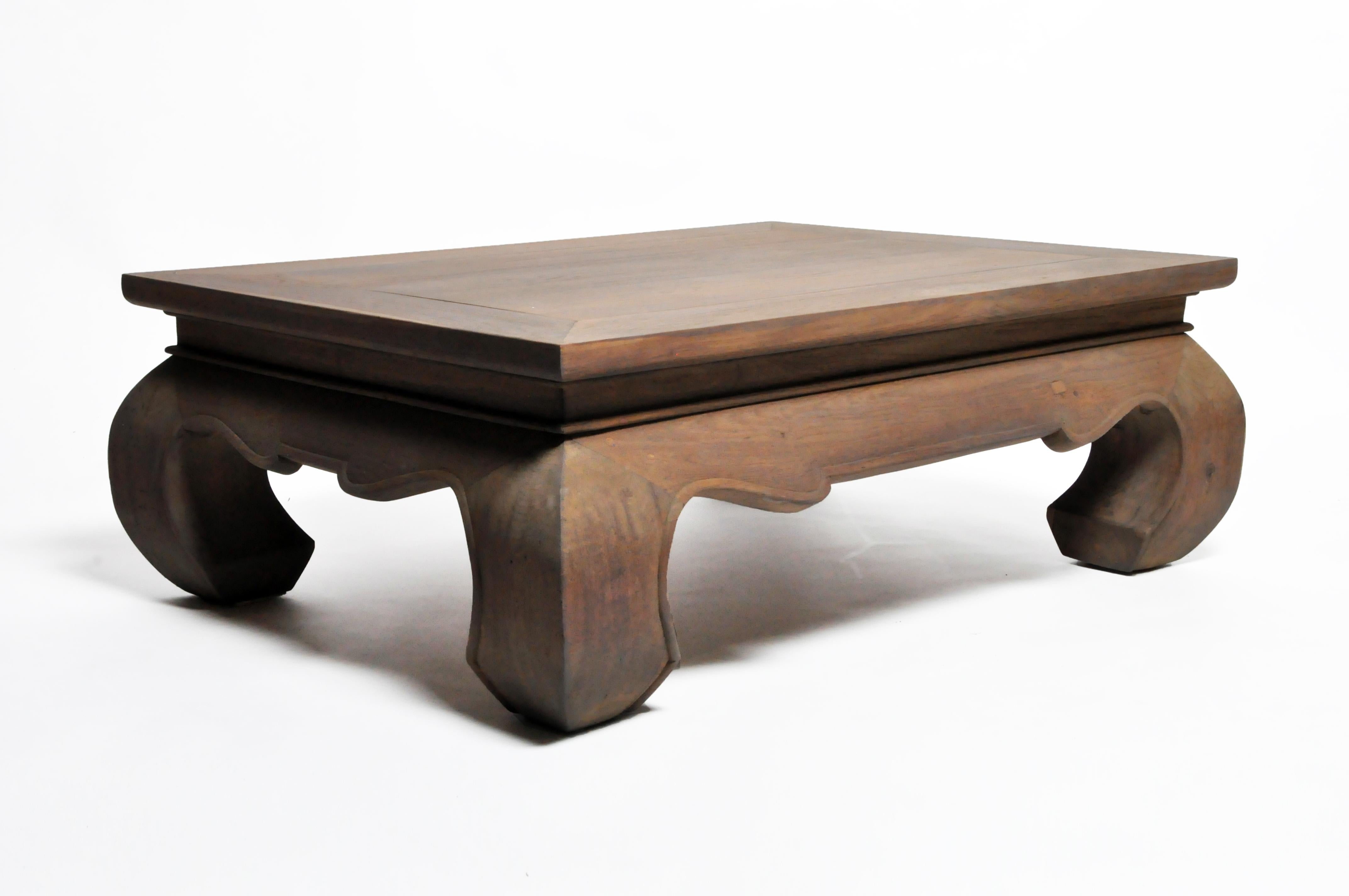 A contemporary Thai Lanna coffee table with large leg supports, freshly carved from teak. Recently refinished color.
  